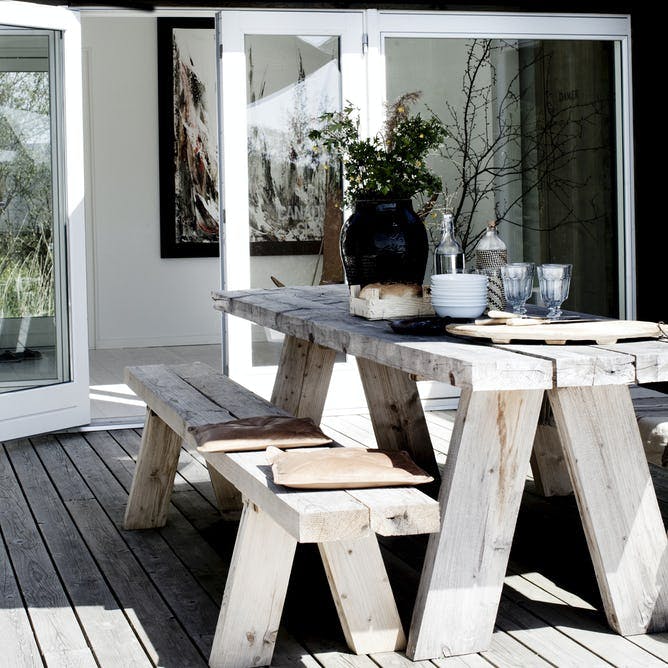 Bjælkebord og bænke på terrassen.
