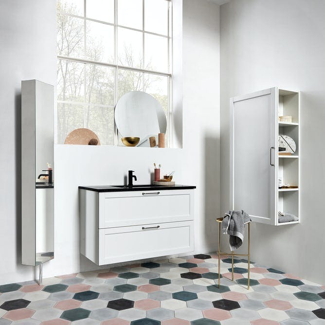 Badeværelse med farvede fliser, store vinduer og højt til loftet.