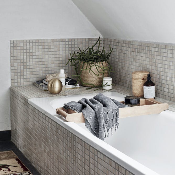 Badeværelse med indbygget badekar i brune nuancer.