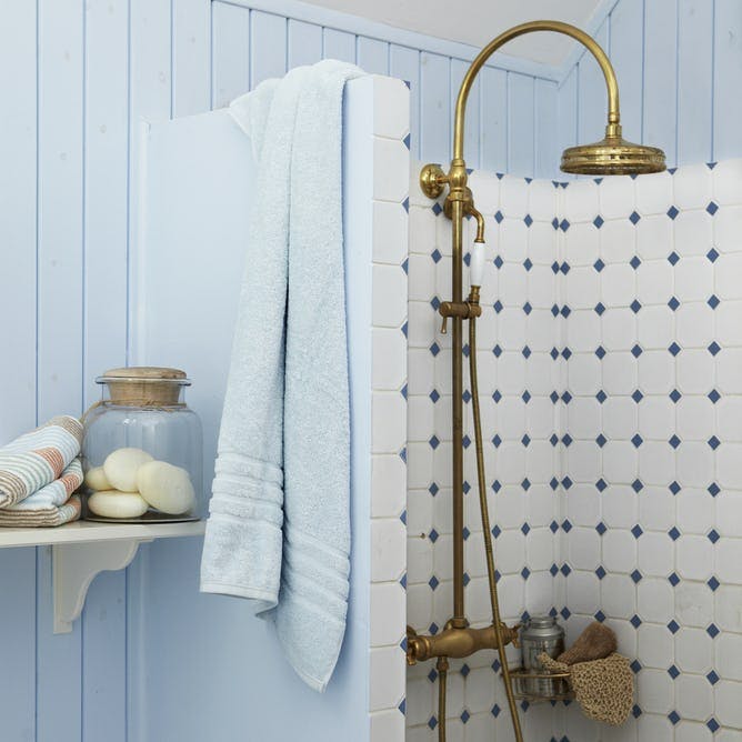 Badeværelse: Guldbruser og armatur i guld.