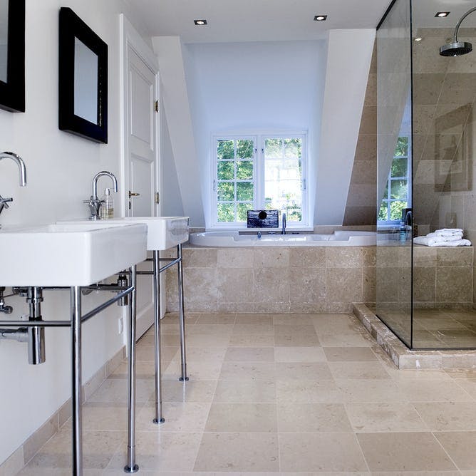 Badeværelse med badekar og dobbelthåndvask.