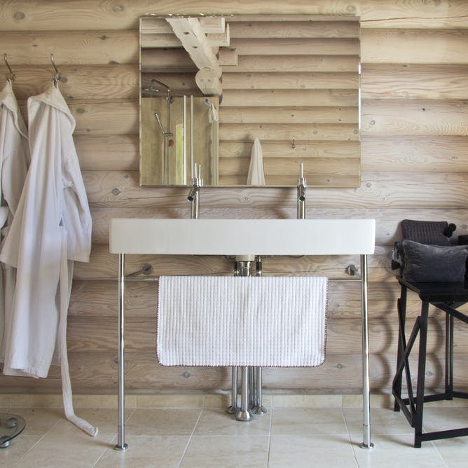 Badeværelse med træbjælker og håndvask på ben.