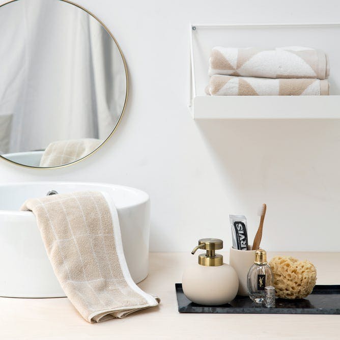 Badeværelse: lyse nuancer og rosafarvede håndklæder.