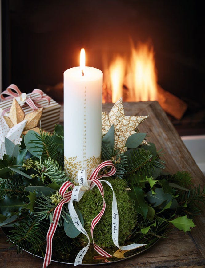 Juledekoration med kalenderlys, mos og gran.