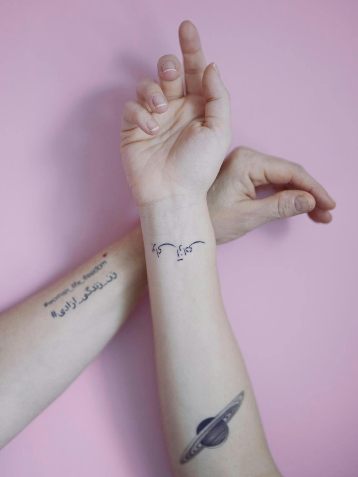 Marjan og Neda har sammen fået lavet tatoveringer, der minder dem om den iranske kamp. På Marjans arm står der ”women, life, freedom” og på Nedas ”for frihed”. ”Denne her bevægelse skal være på min krop, så jeg aldrig nogensinde glemmer den," siger M