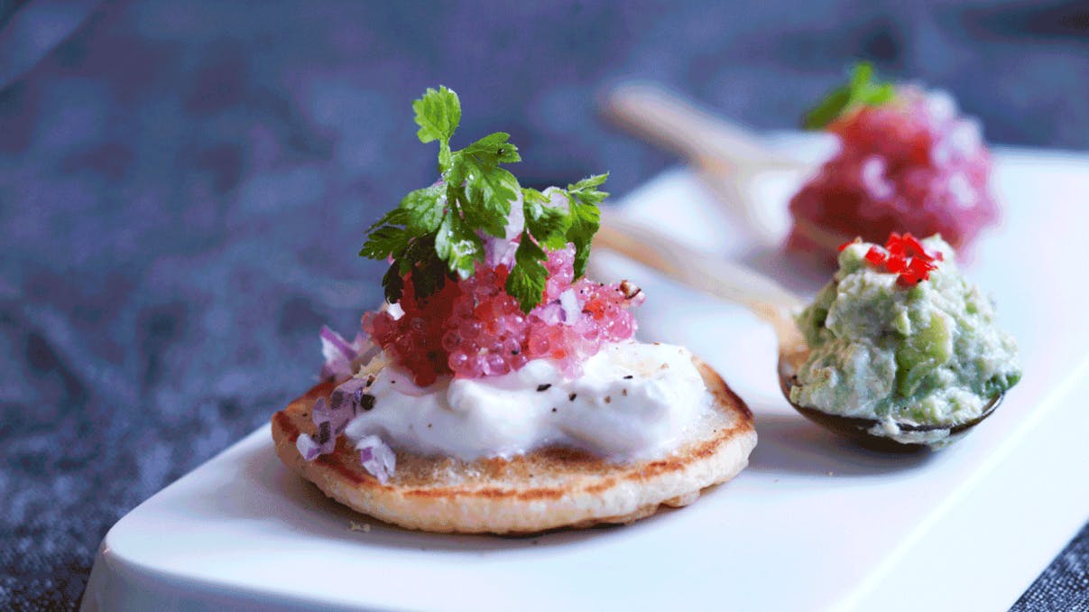 Små blinis med stenbiderrogn og avokado toppet med kørvel