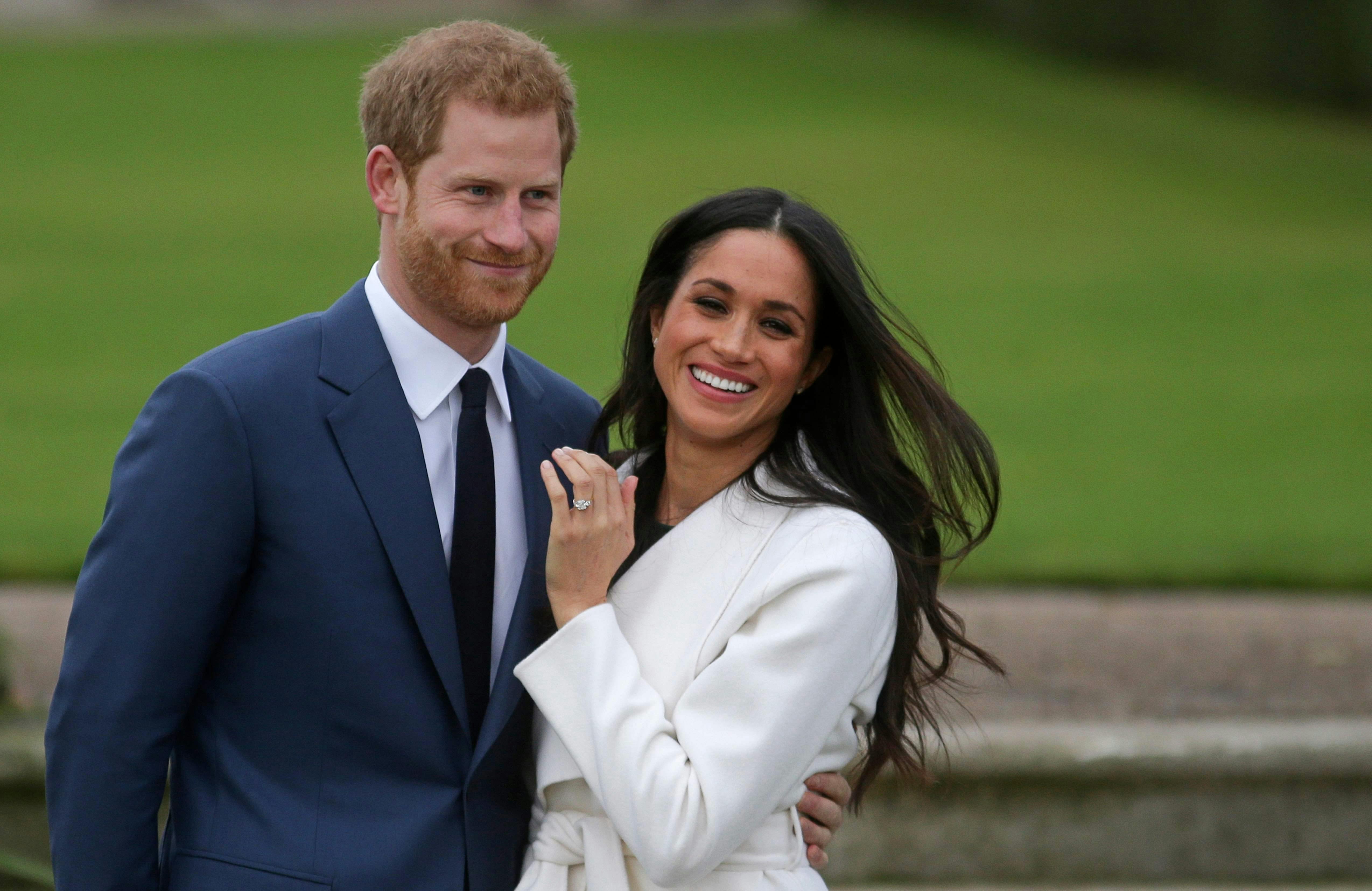 Prince Harry stands with his fiancée US actress Meghan Markle