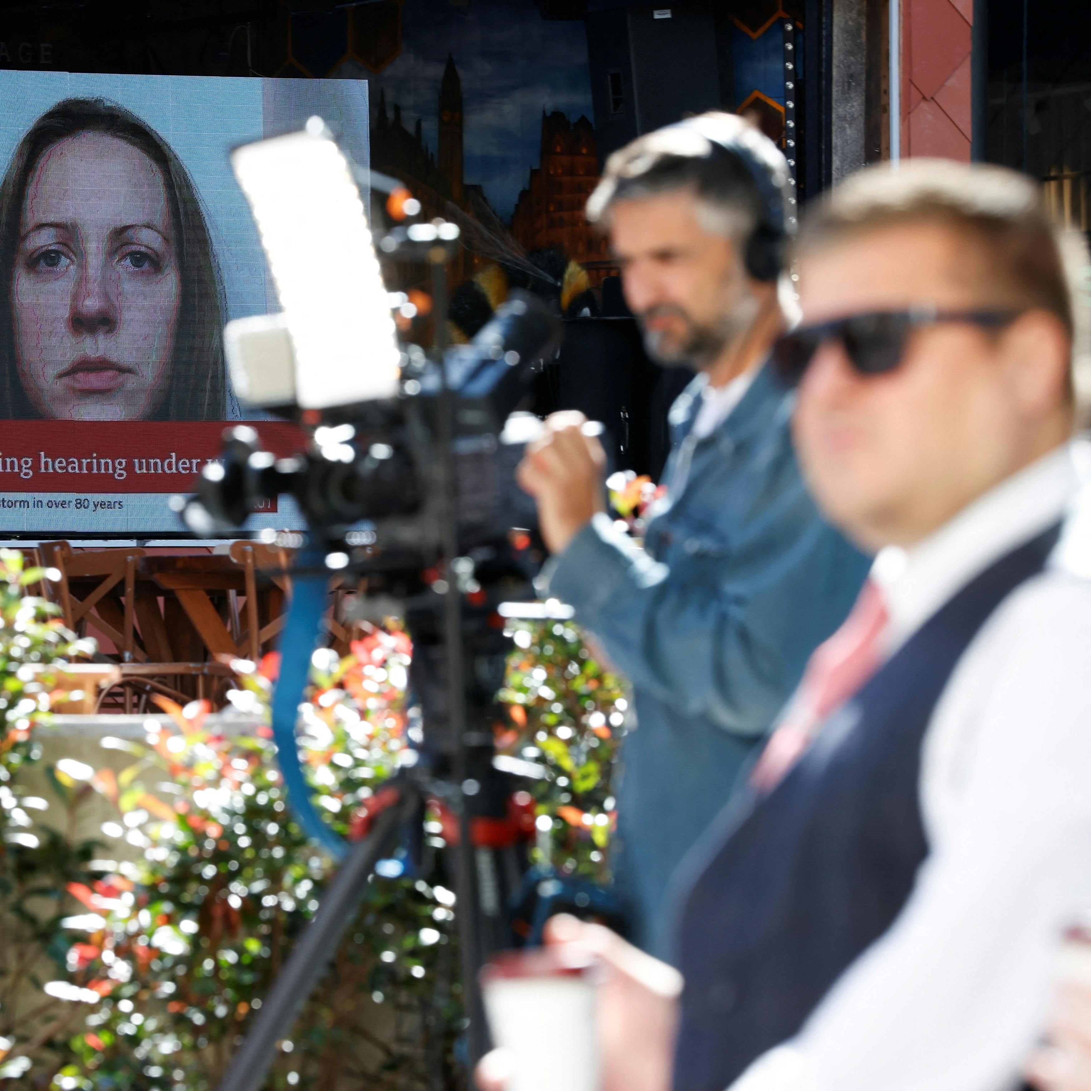 Members of the media work near a large screen showing a picture of convicted hospital nurse Lucy Letby, ahead of her sentencing, outside the Manchester Crown Court, in Manchester, Britain, August 21, 2023. REUTERS/Phil Noble