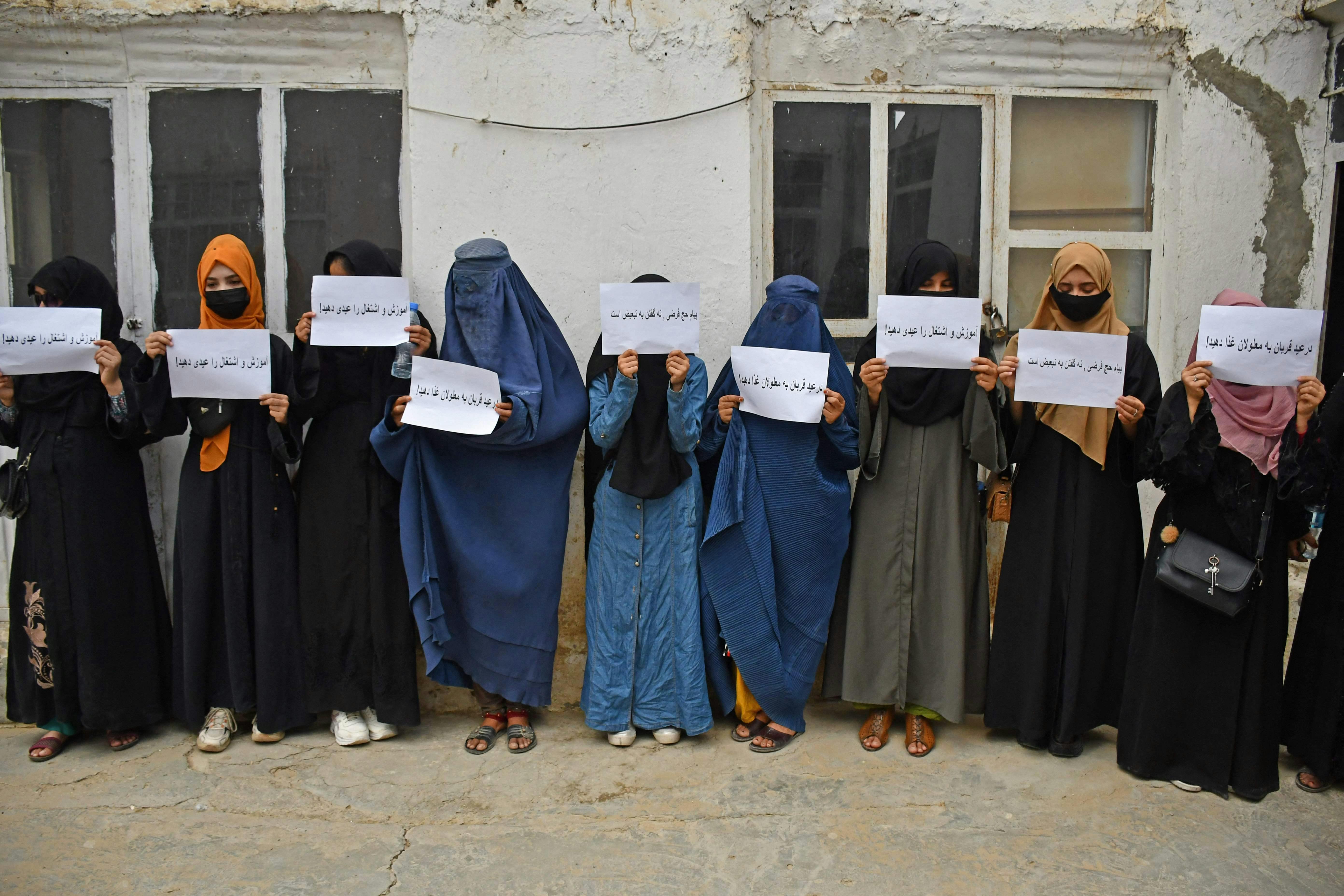Afghan women hold placards demanding their right to education, in Mazar-i-Sharif on June 26, 2023. (Photo by Atif ARYAN / AFP)