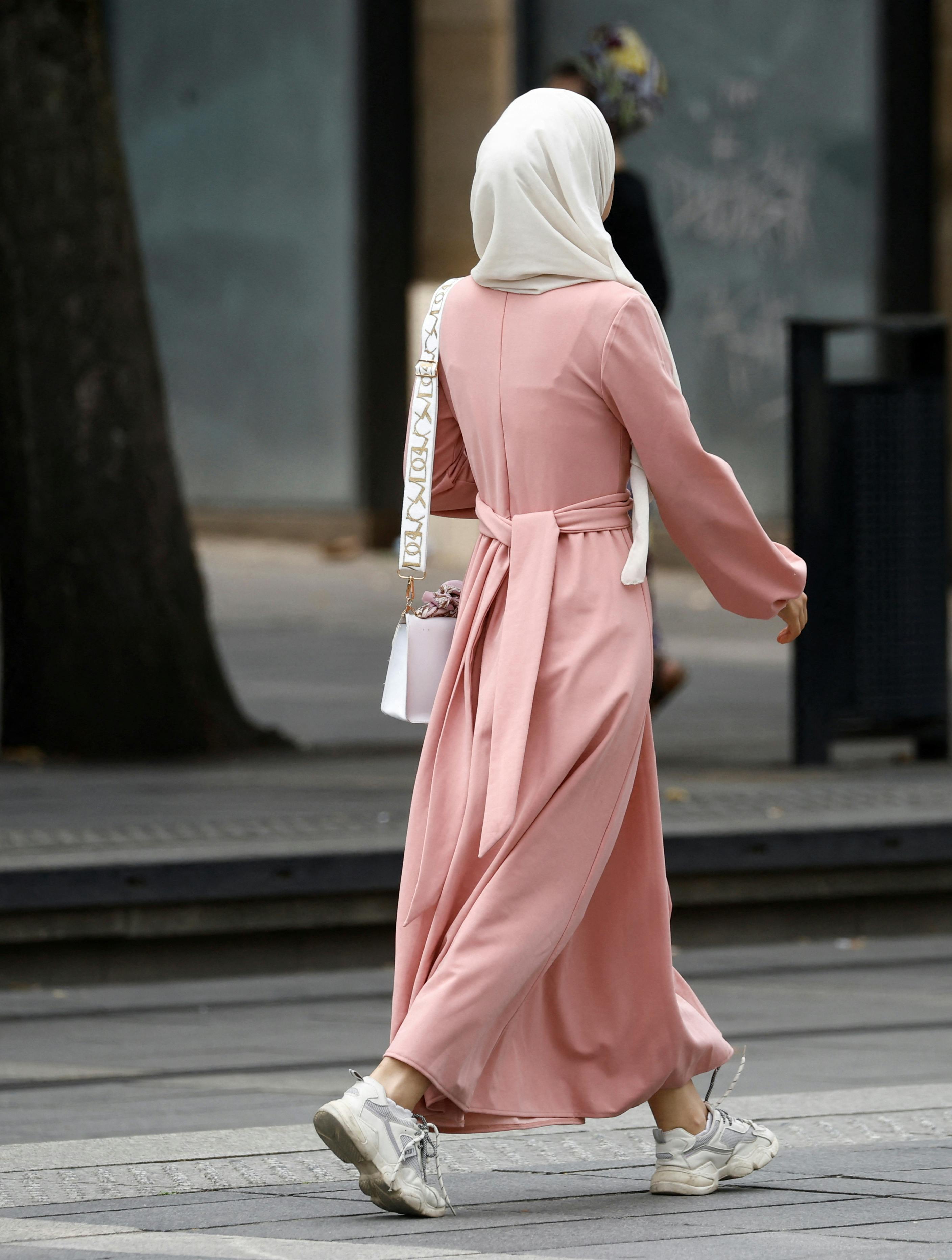 A Muslim woman, wearing the style of dress called an abaya, walks in a street in Nantes, France, August 29, 2023. REUTERS/Stephane Mahe