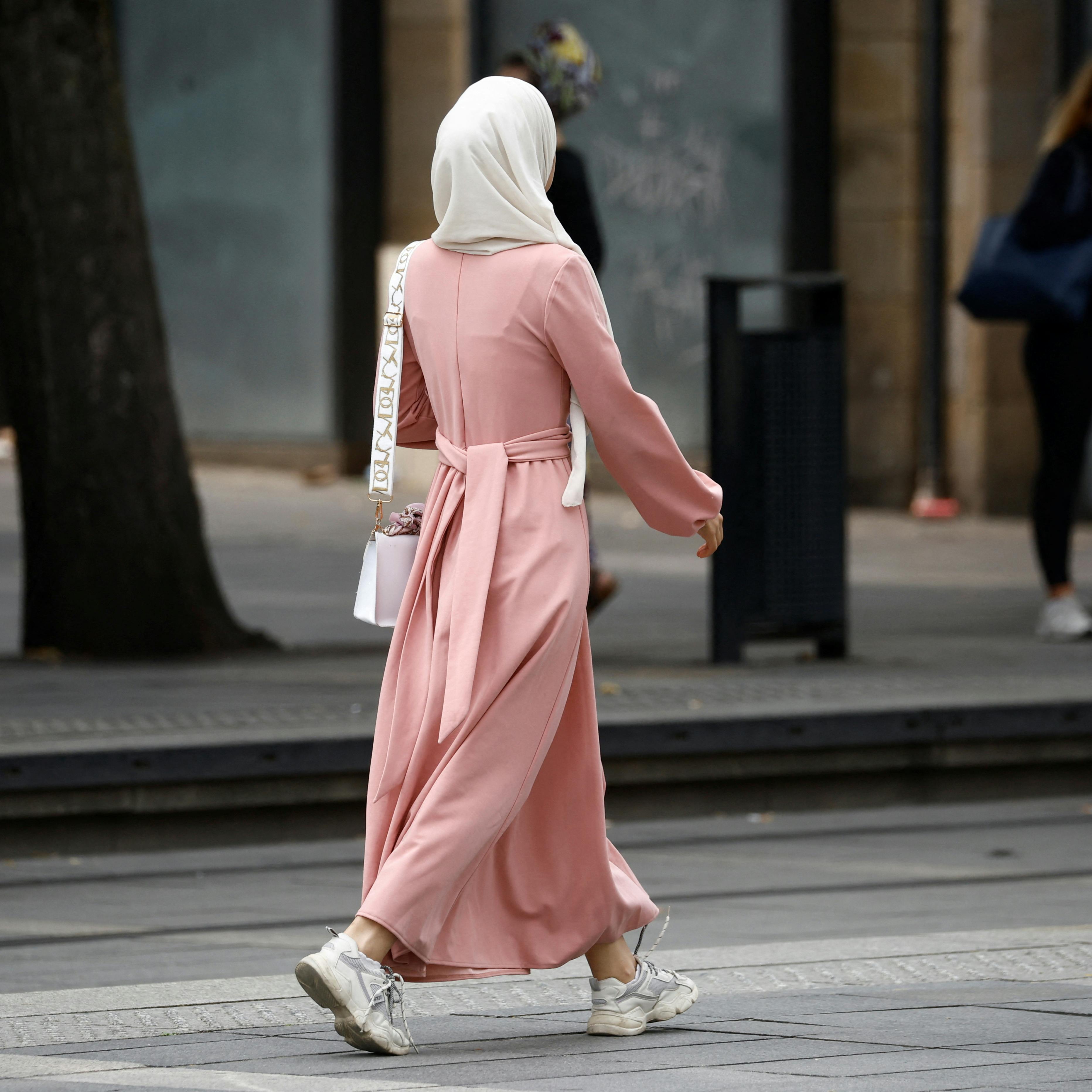 A Muslim woman, wearing the style of dress called an abaya, walks in a street in Nantes, France, August 29, 2023. REUTERS/Stephane Mahe