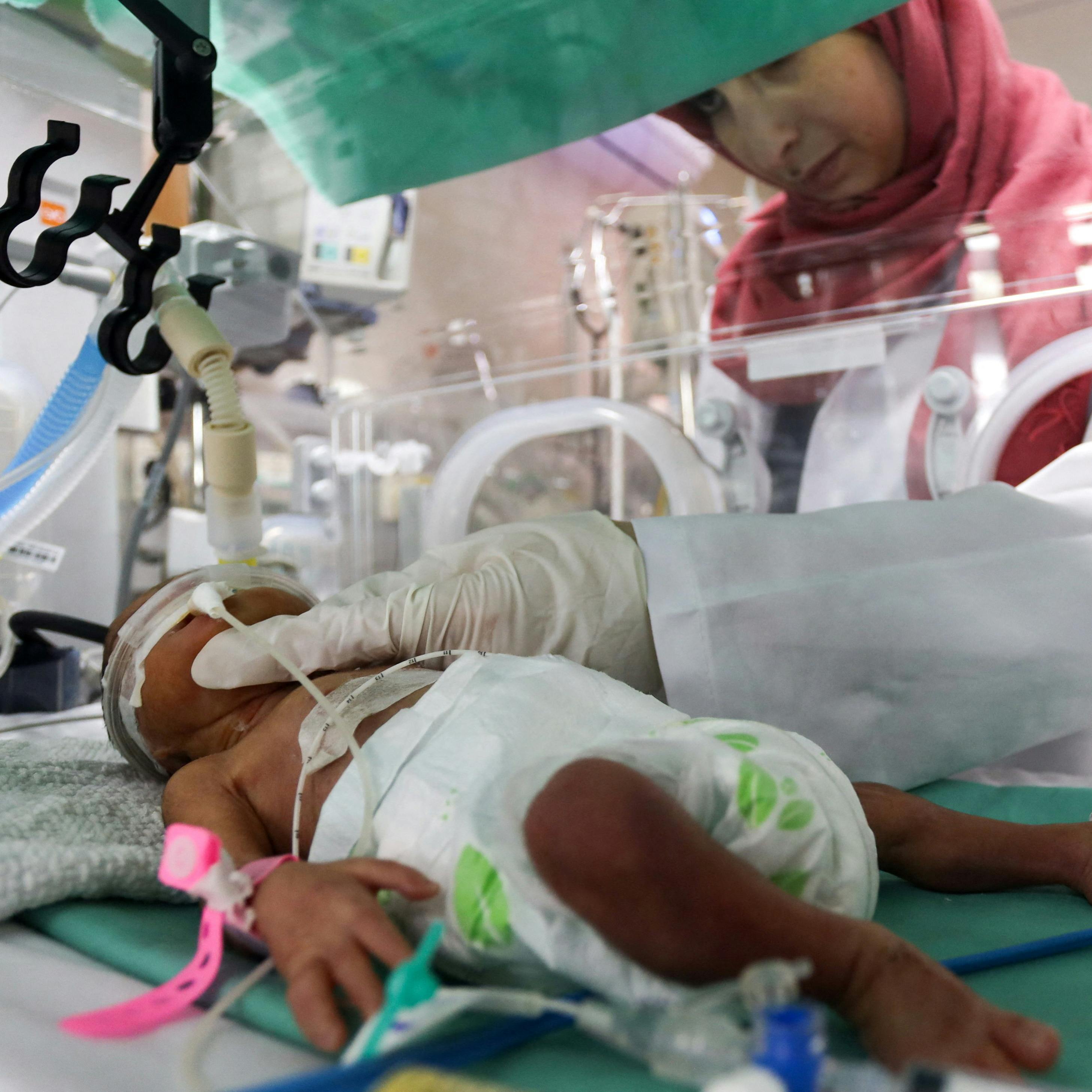 A medical worker assists a premature Palestinian baby who lies in an incubator at the maternity ward of Shifa Hospital, which according to health officials is about to shut down as it runs out of fuel and power, as the conflict between Israel and the Palestinian Islamist group Hamas continues, in Gaza City October 22, 2023. REUTERS/Mohammed Al-Masri