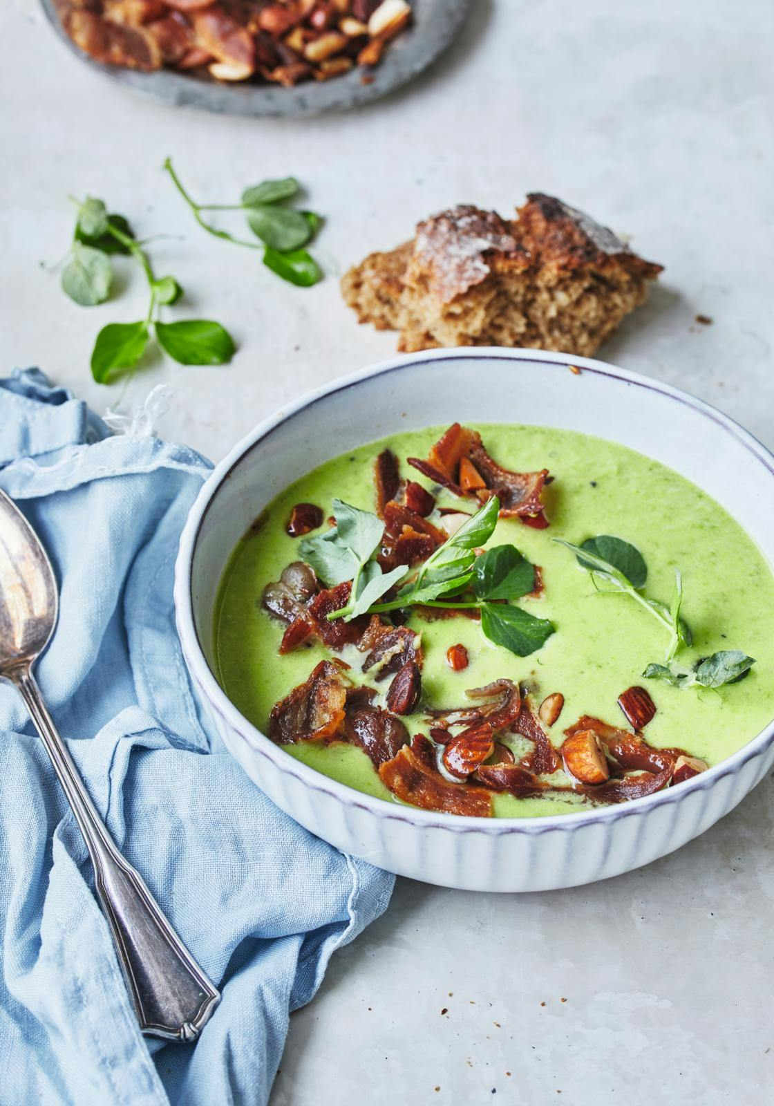 Cremet ærtesuppe med bacon, mandler og ærteskud