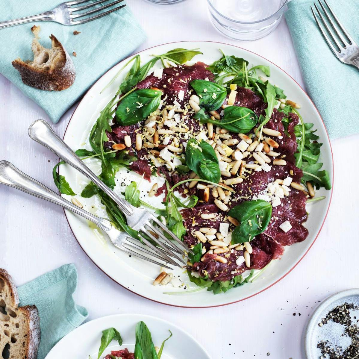 Nem carpaccio med ristede pinjekerner, parmesan og basilikum