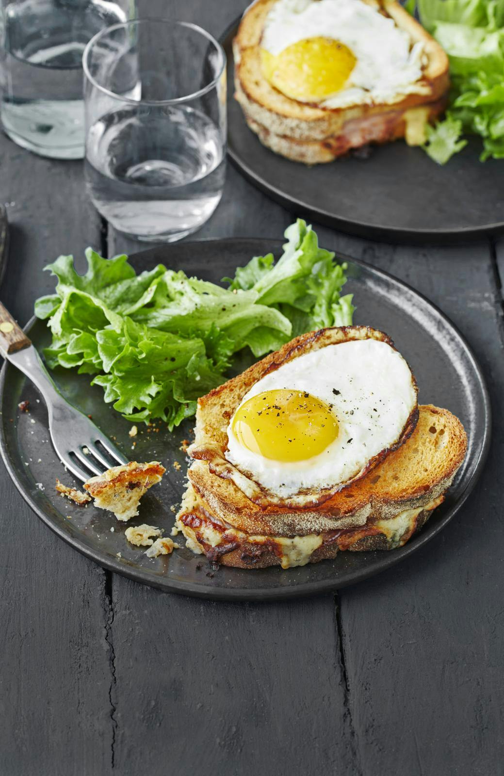 Croque-madame med spejlæg og grønt - på gråligt service.