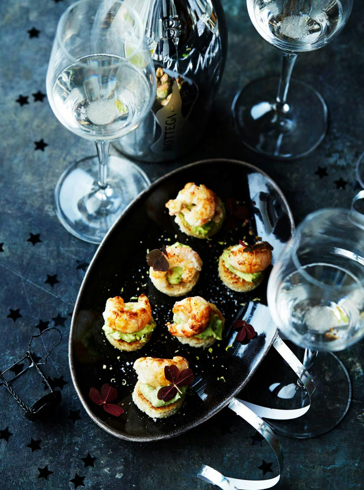 Lækker og nem nytårssnack på sort fad, på et pyntet nytårsbord.