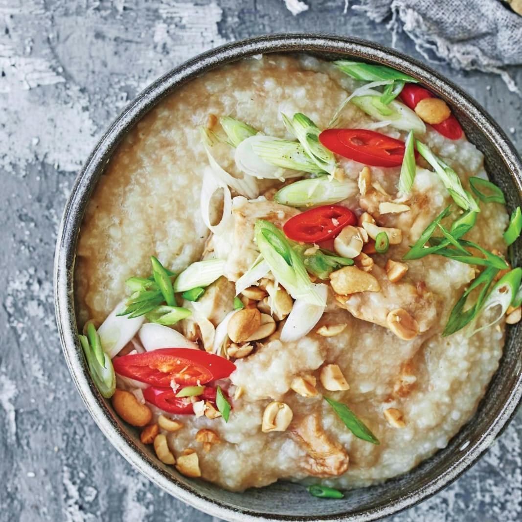 Congee med soyastegt kylling og toppet med chili, forårsløg og peanuts
