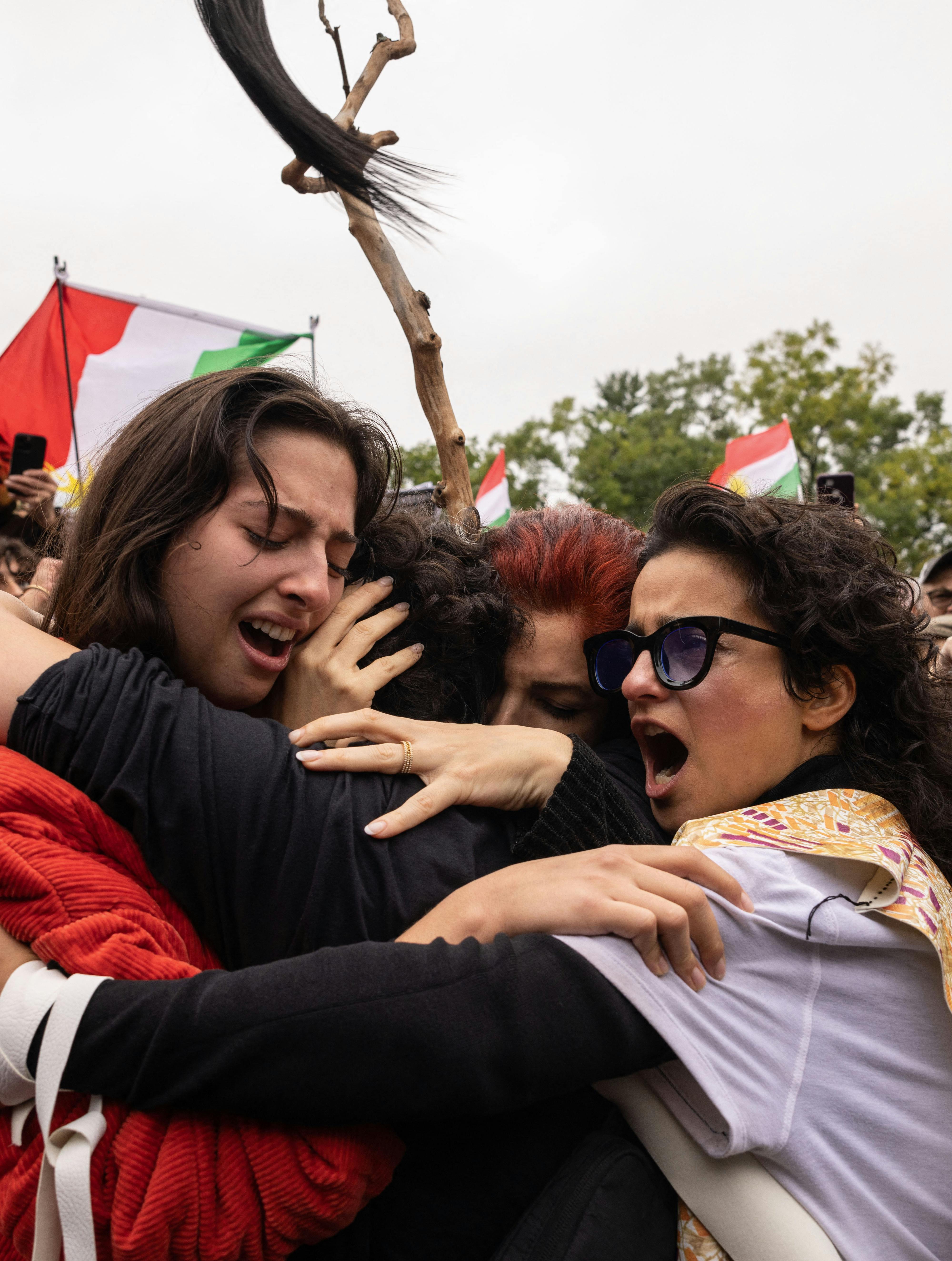 Activists hug each other after cutting their hair in protest over the death of Mahsa Amini in the custody of the Iran's notorious morality police in New York on October 1, 2022. Yuki IWAMURA / AFP