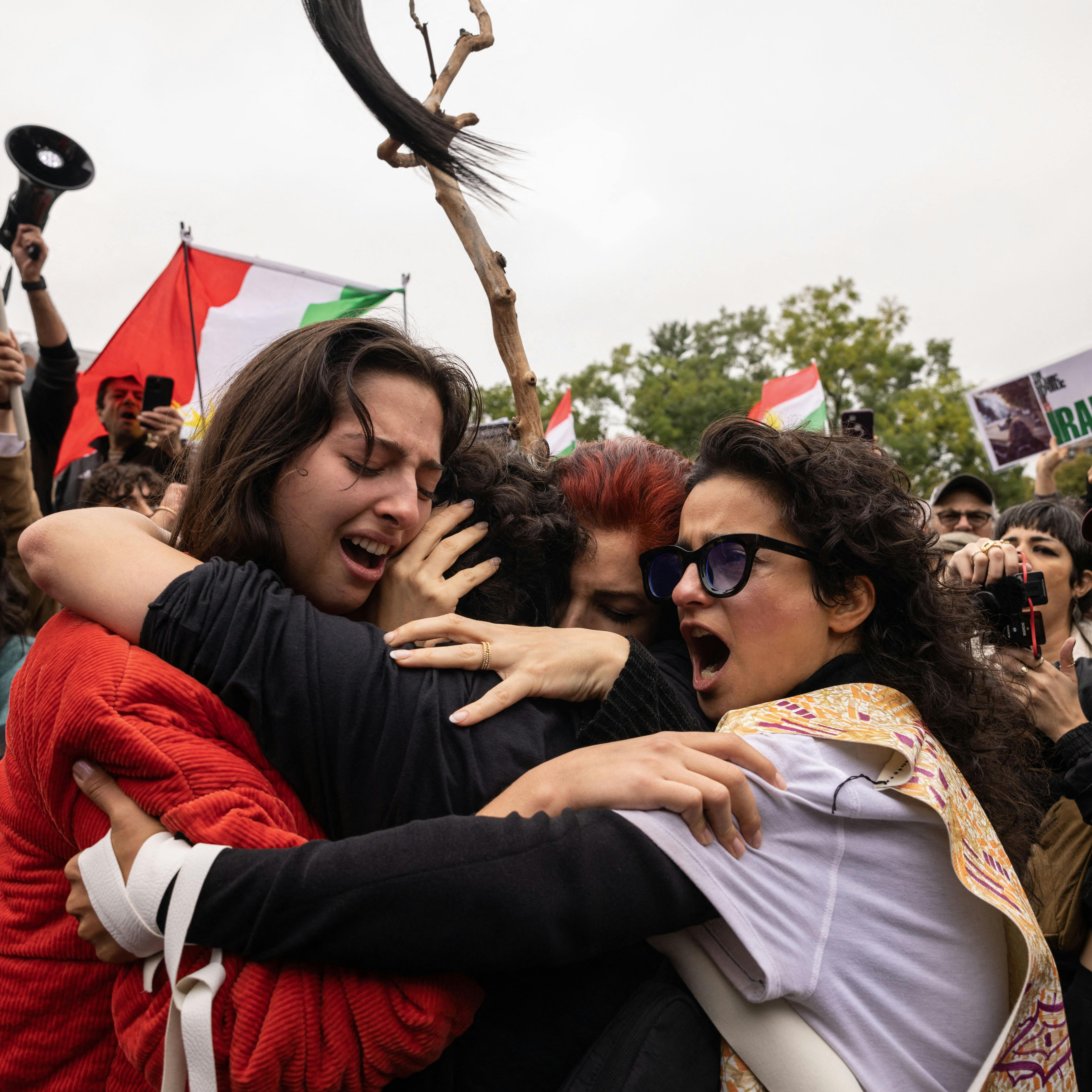 Activists hug each other after cutting their hair in protest over the death of Mahsa Amini in the custody of the Iran's notorious morality police in New York on October 1, 2022. Yuki IWAMURA / AFP