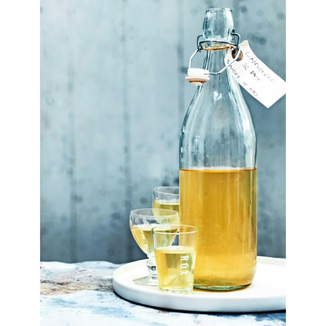 Frisk, hjemmelavet limoncello i fin flaske med mærkat.