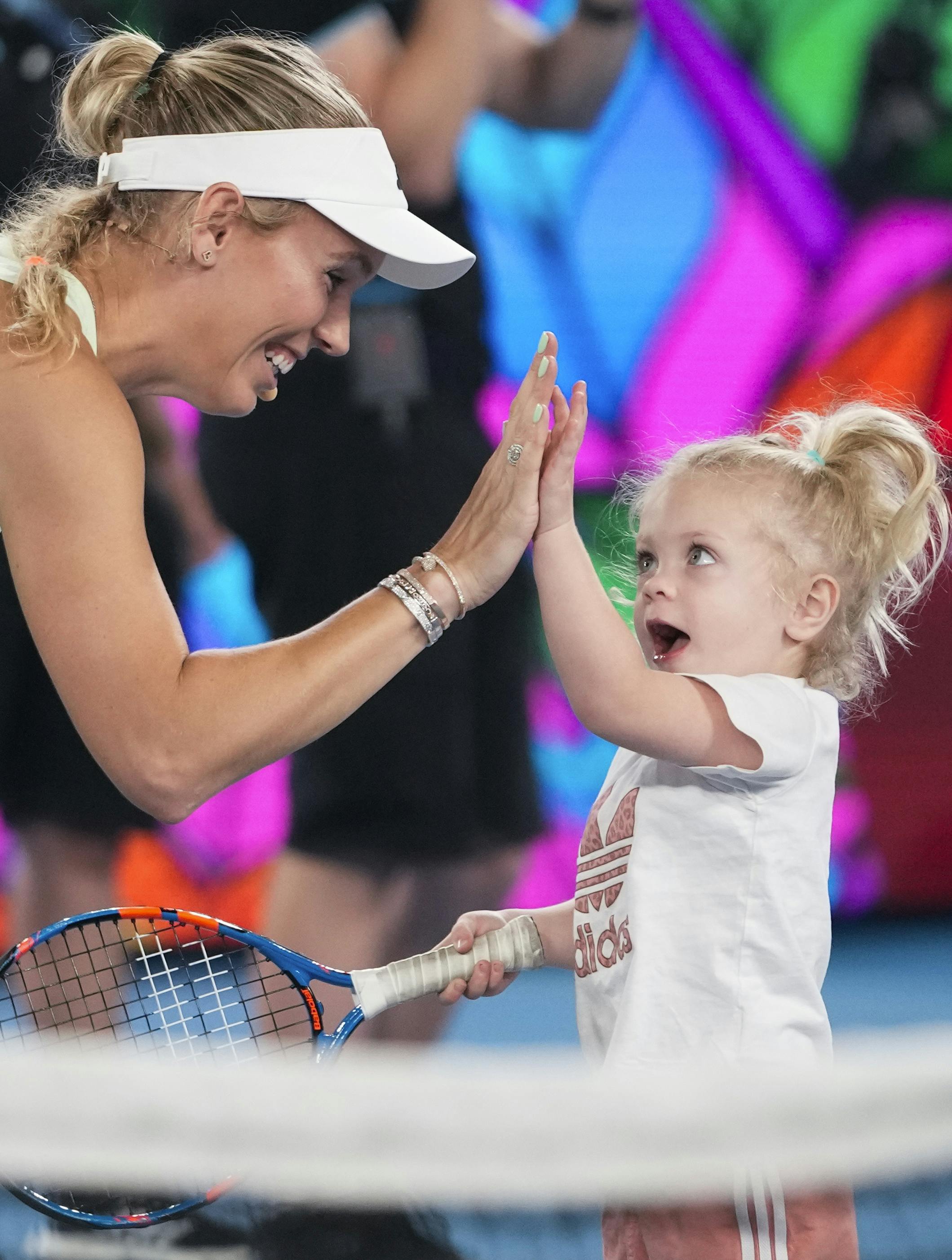 Denmark's Caroline Wozniacki reacts with her daughter Olivia during a charity on Rod Laver Arena ahead of the Australian Open tennis championships at Melbourne Park, Melbourne, Australia, Saturday, Jan. 13, 2024. (AP Photo/Alessandra Tarantino)