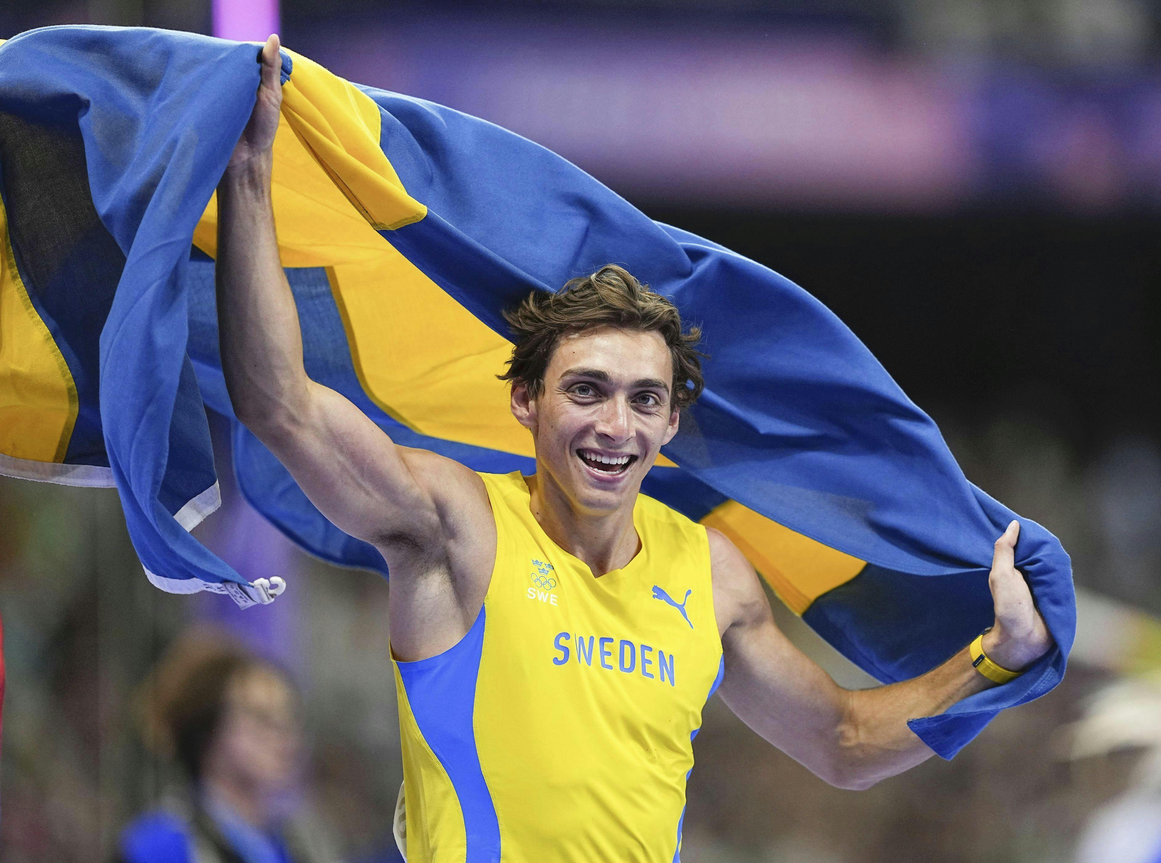 Sweden's Armand Duplantis celebrates with his national flag after winning the men's pole vault event with a new world record of 6.25 meters at the Paris Olympics on Aug. 5, 2024, at Stade de France in Saint-Denis, near the French capital. (Kyodo via AP Images) ==Kyodo