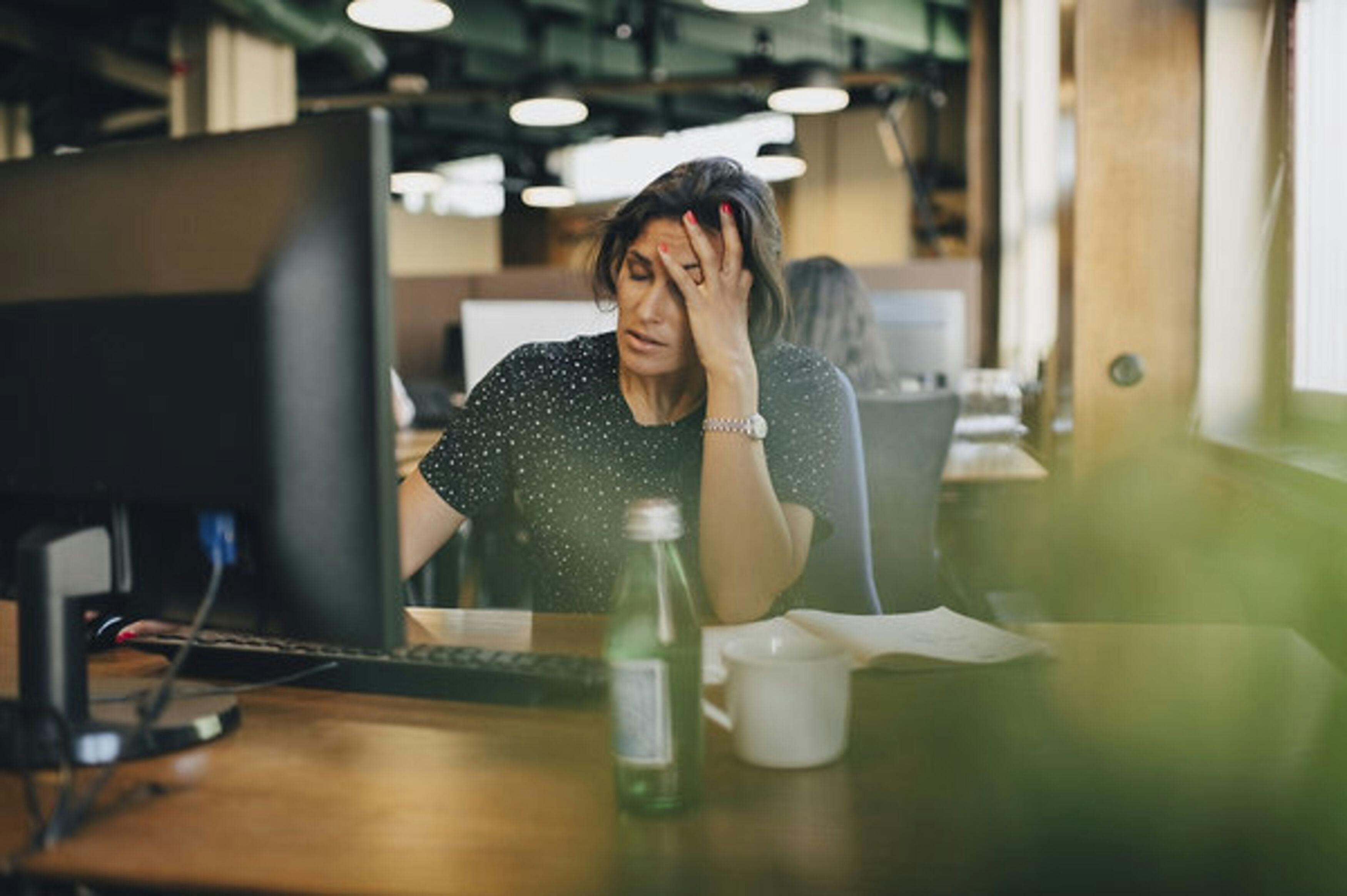 Tired businesswoman with head in hand