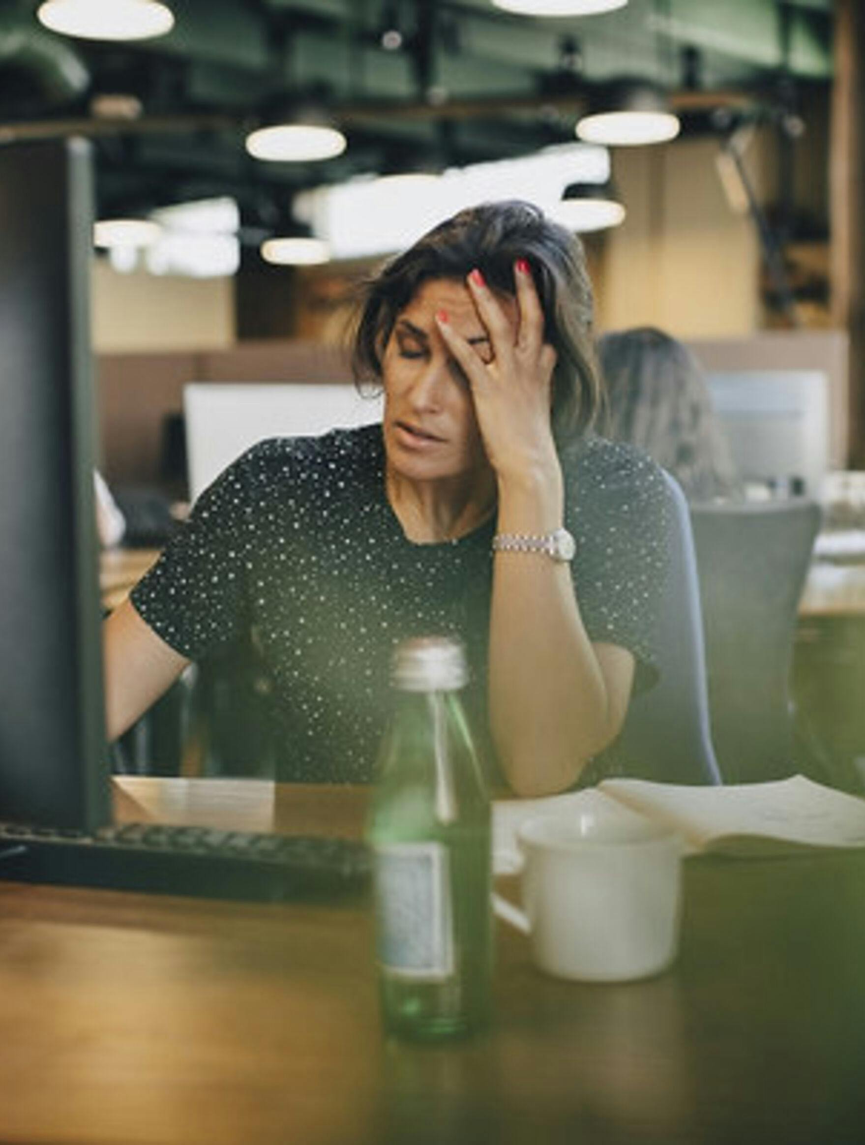 Tired businesswoman with head in hand
