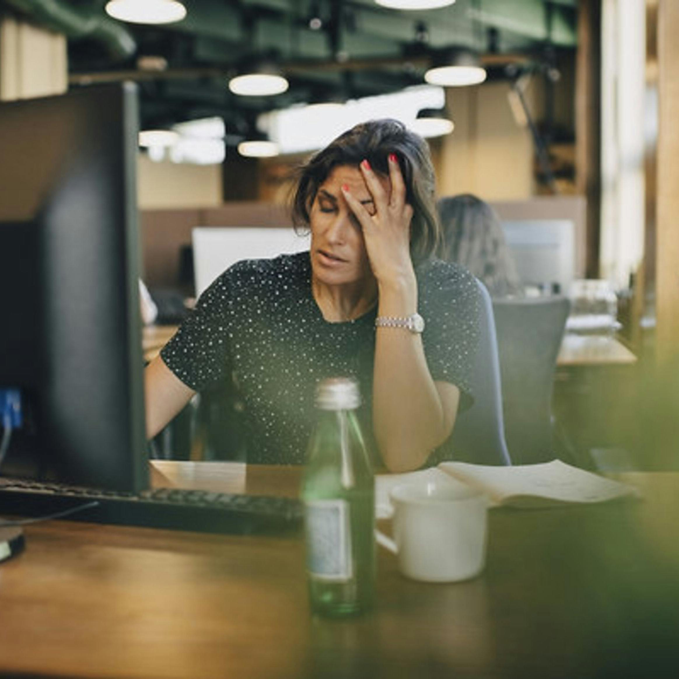 Tired businesswoman with head in hand