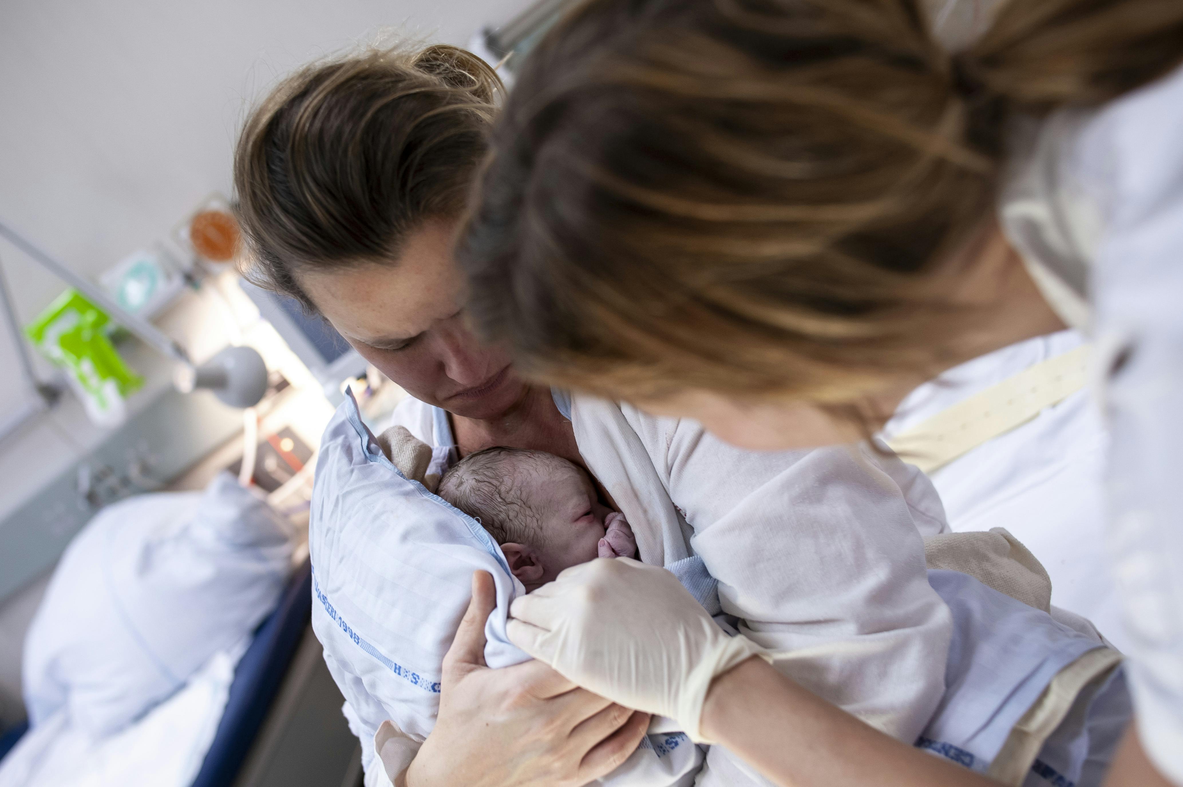 Kvinde lige efter fødsel med sin nyfødte baby på maven. På Rigshospitalet.