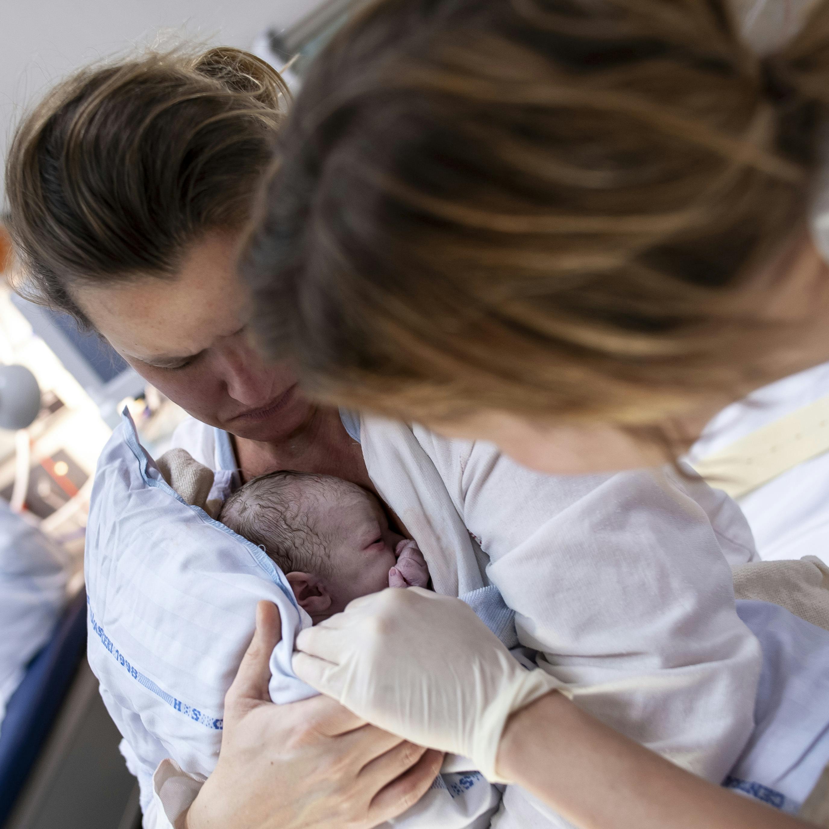 Kvinde lige efter fødsel med sin nyfødte baby på maven. På Rigshospitalet.
