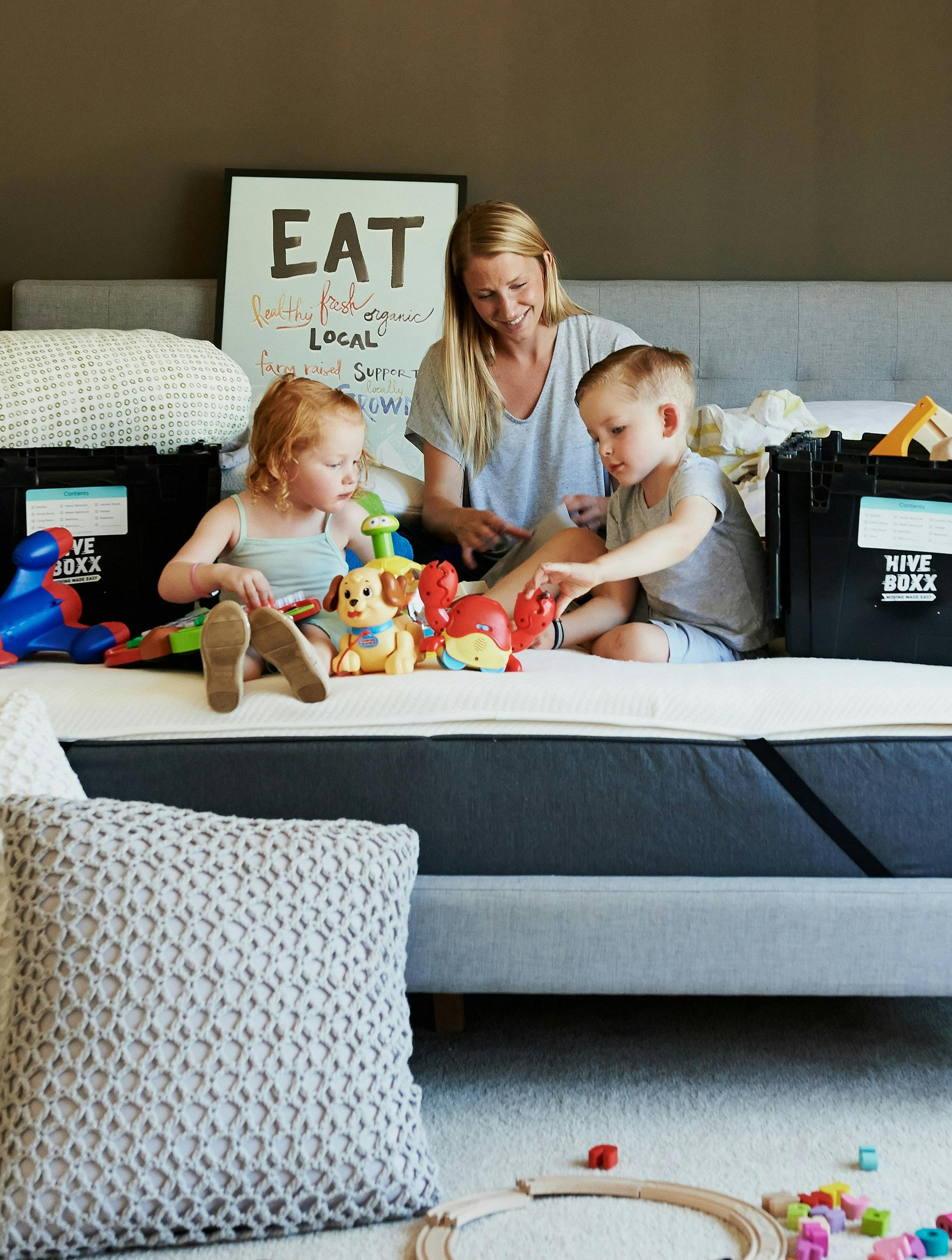 Mor rydder op i legetøj med sine børn