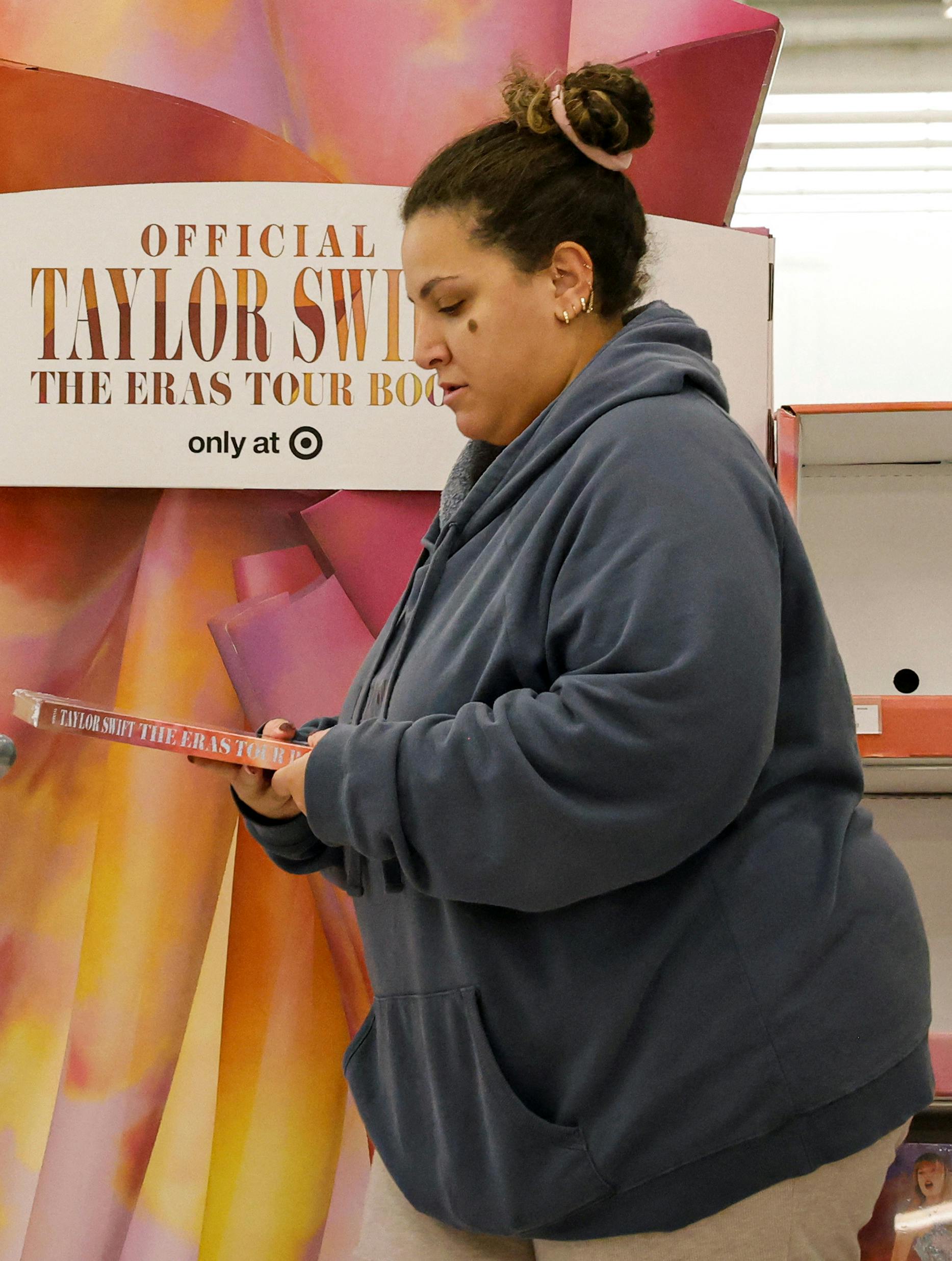 A shopper picks up Taylor Swift's new Eras Tour book