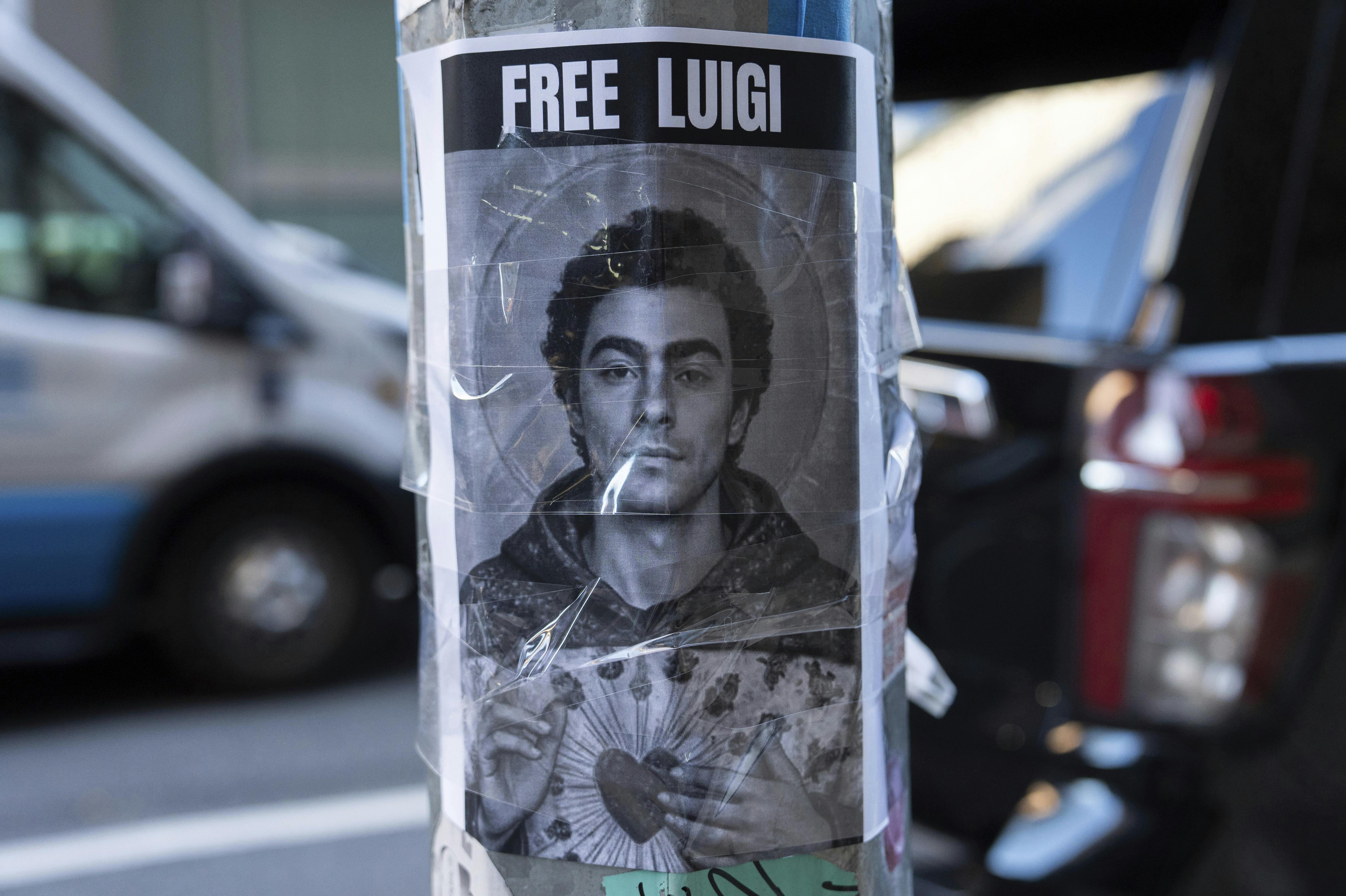 A poster depicting Luigi Mangione hangs outside the New York Hilton Midtown hotel, in New York, Dec. 12, 2024. (AP Photo/Julia Demaree Nikhinson)