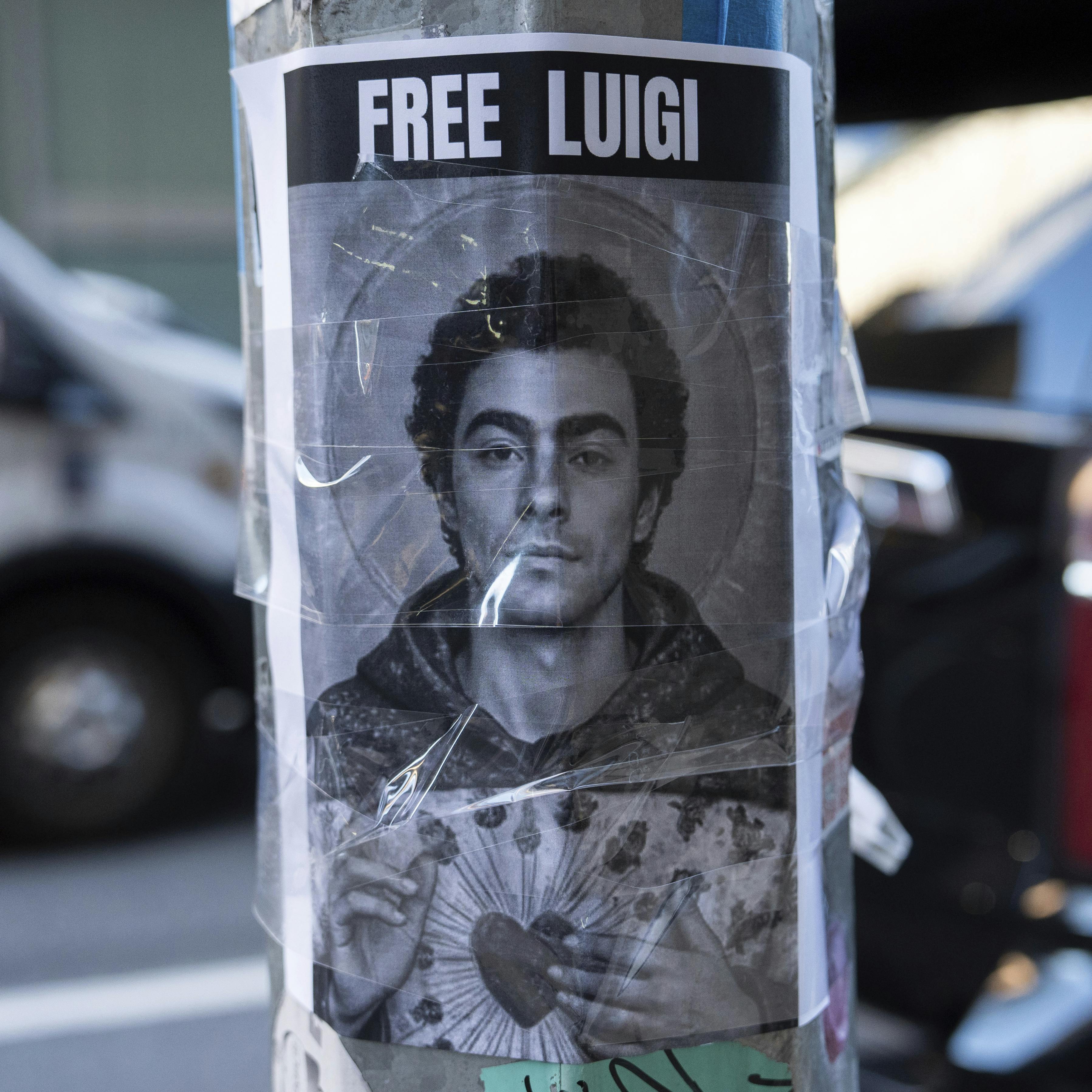 A poster depicting Luigi Mangione hangs outside the New York Hilton Midtown hotel, in New York, Dec. 12, 2024. (AP Photo/Julia Demaree Nikhinson)