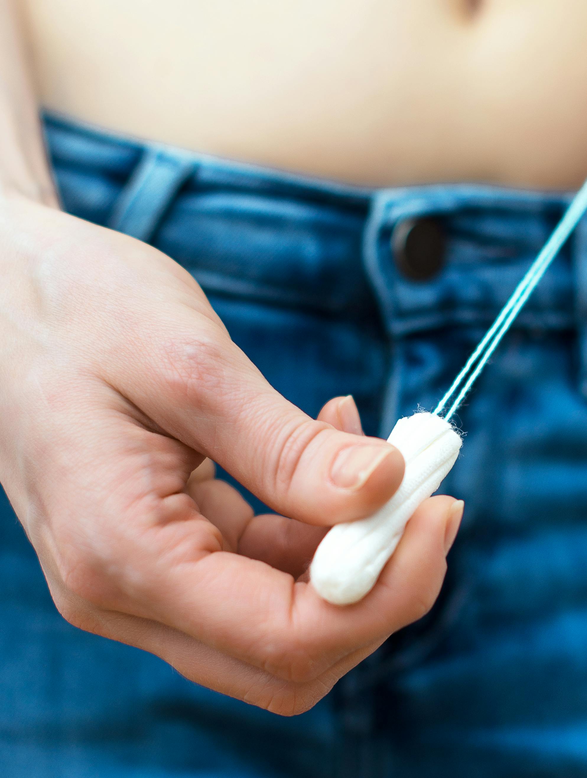 Woman holding tampon in her hands.