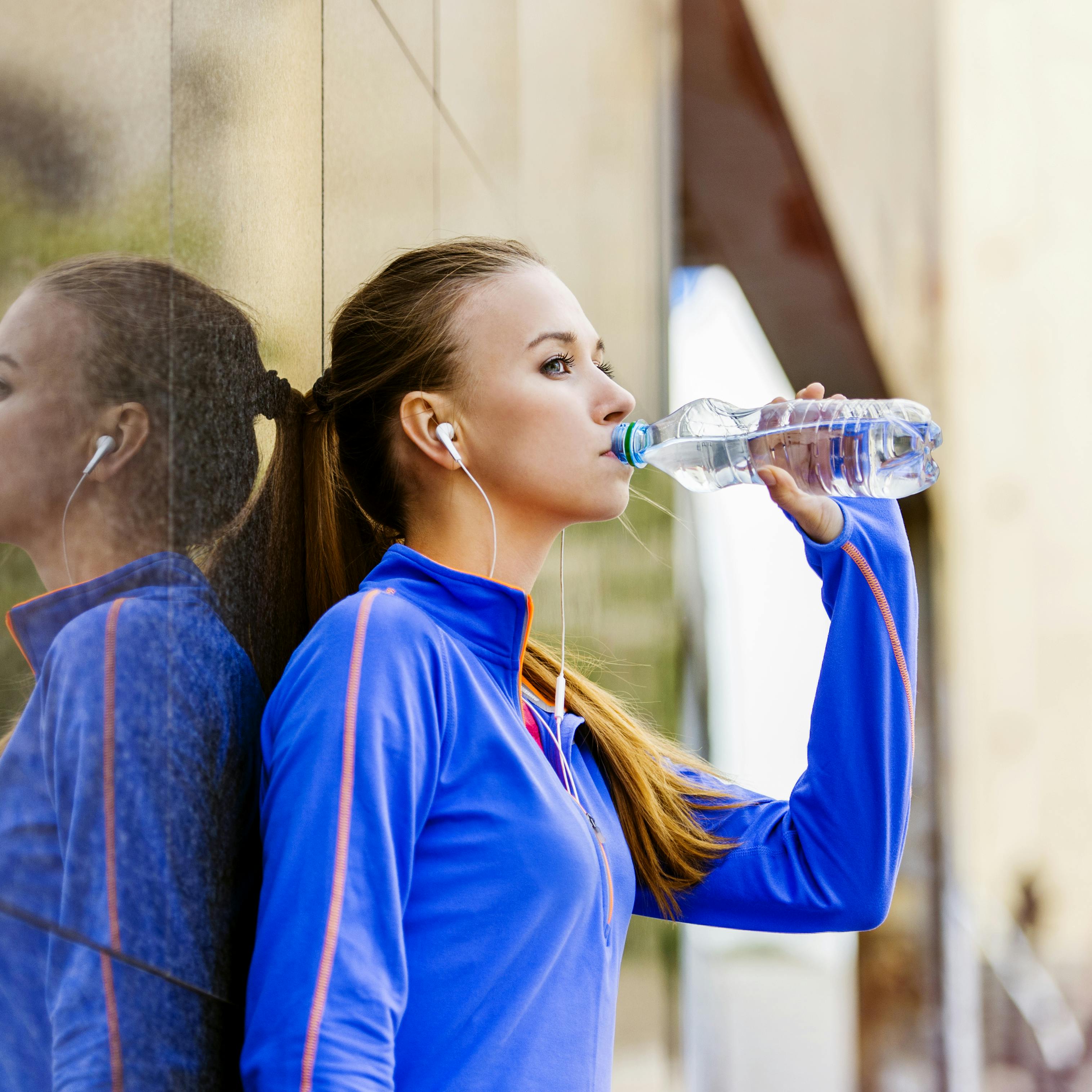 Kvinde drikker vand efter at have løbet maraton