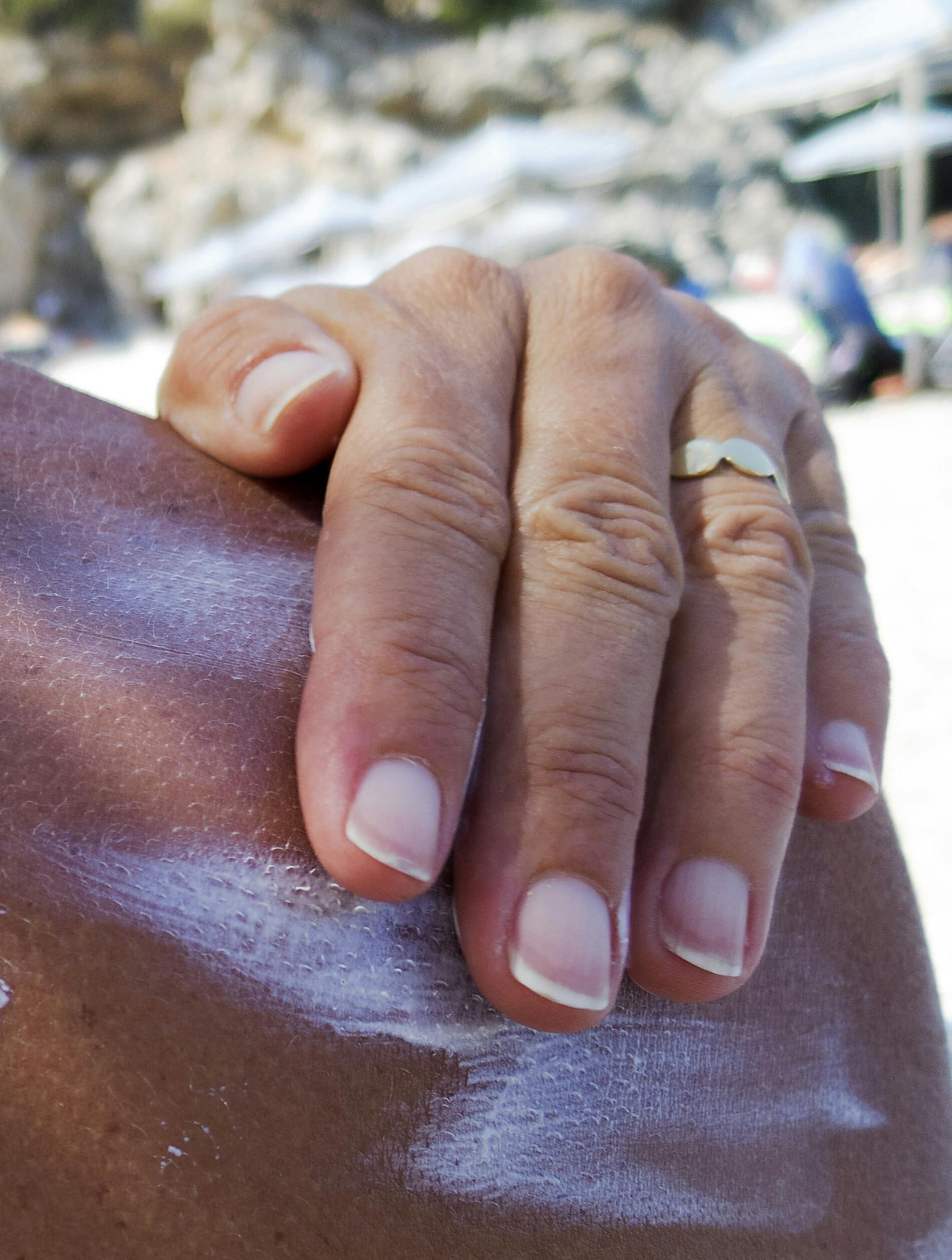 Kvinde der smører solcreme på