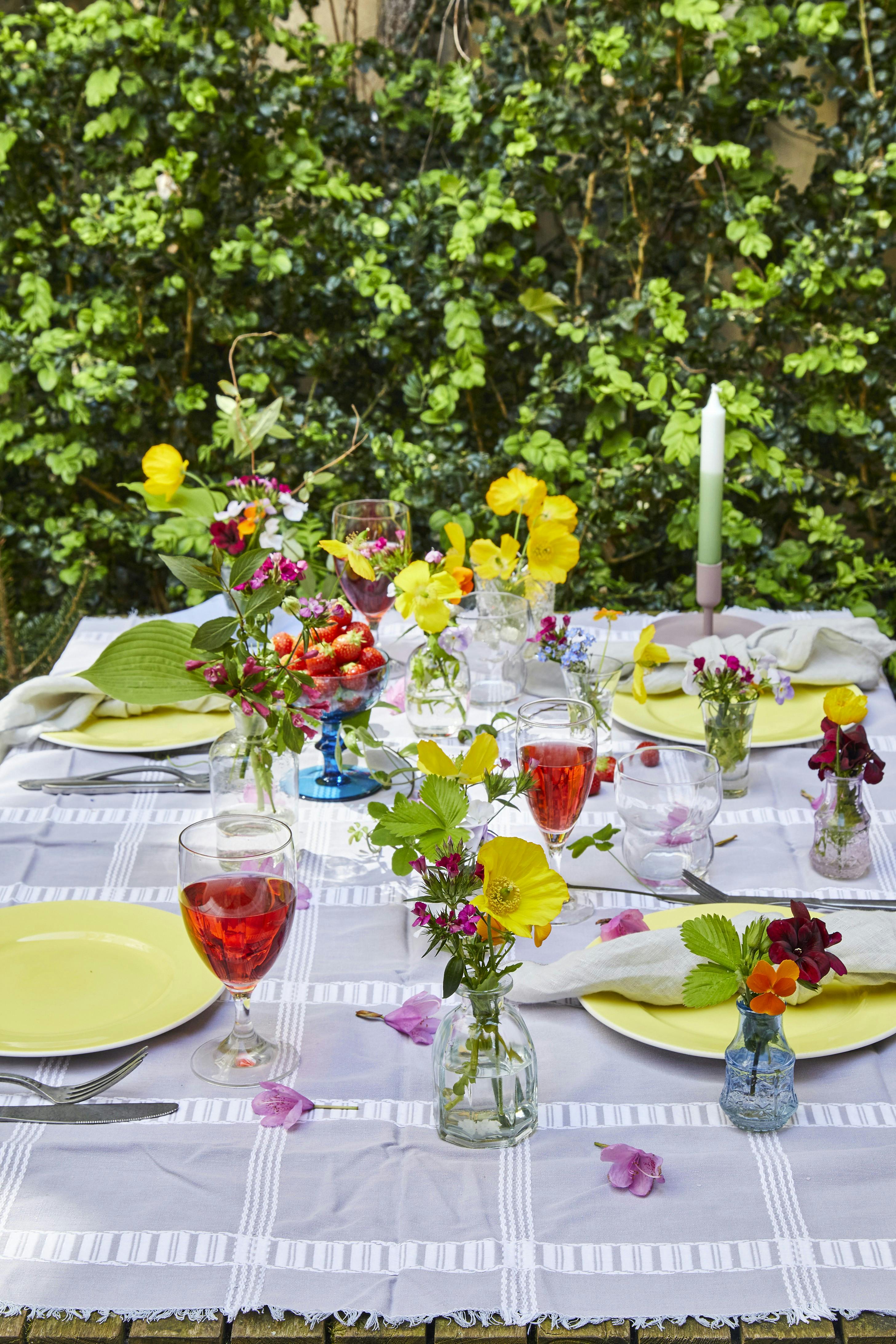 Klip løs af havens blomster og miks dem tilfældigt i små glasvaser.