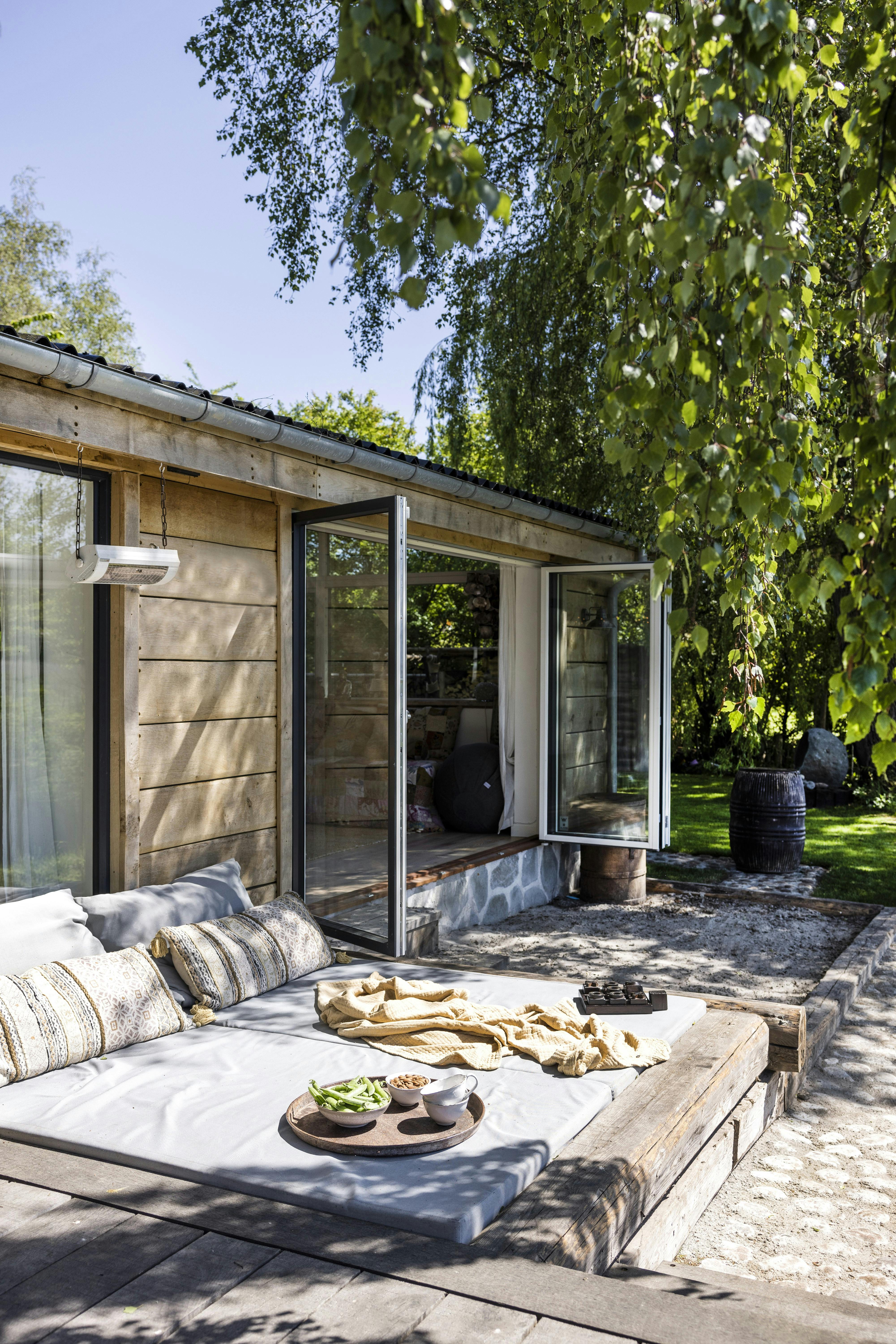 Terrassen er lige så bred som sommerhuset, men er blevet bygget i forskellige niveauer
