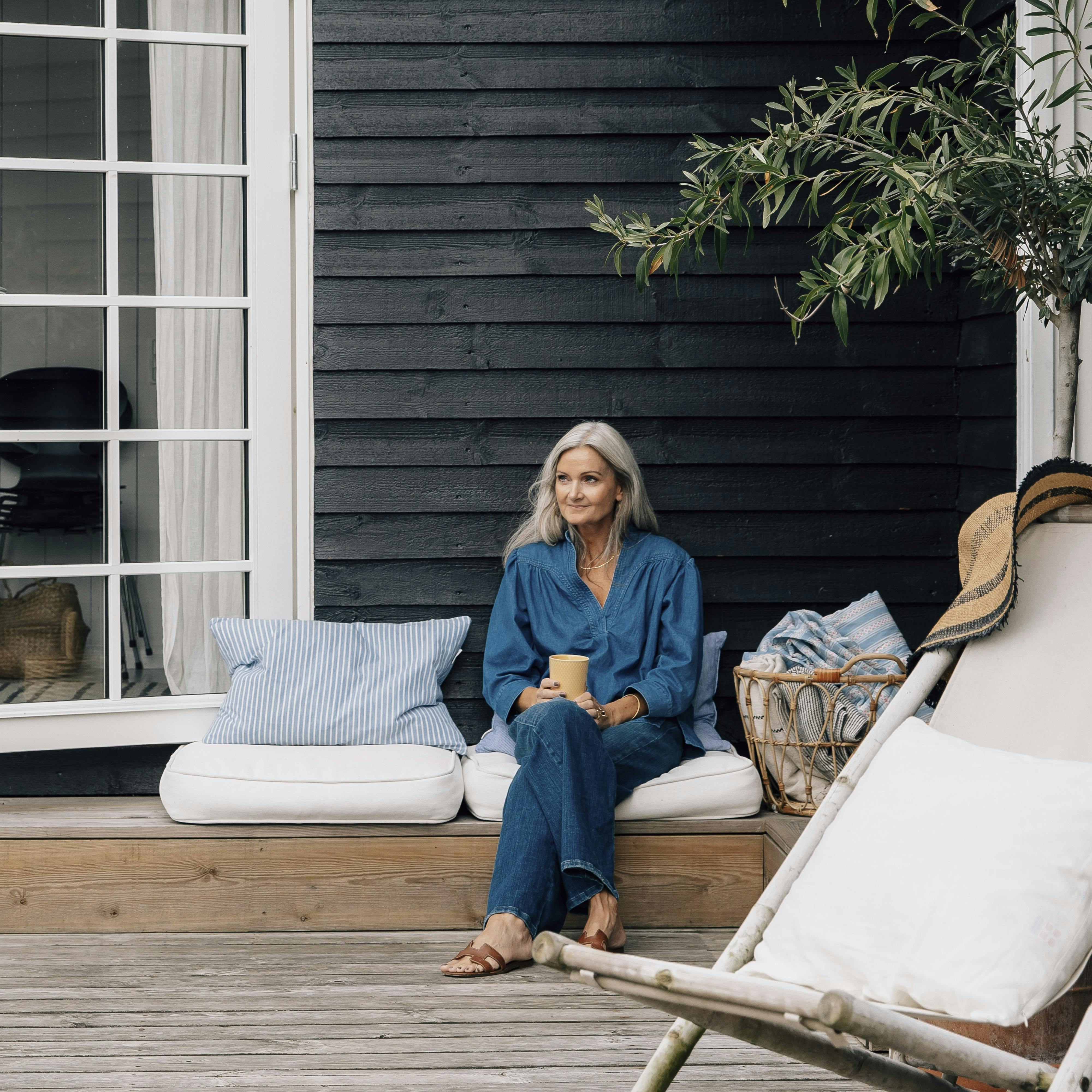 Her sidder Helene i loungeområdet på terrassen, hvor hun nyder mange timer i løbet af dagene deroppe.