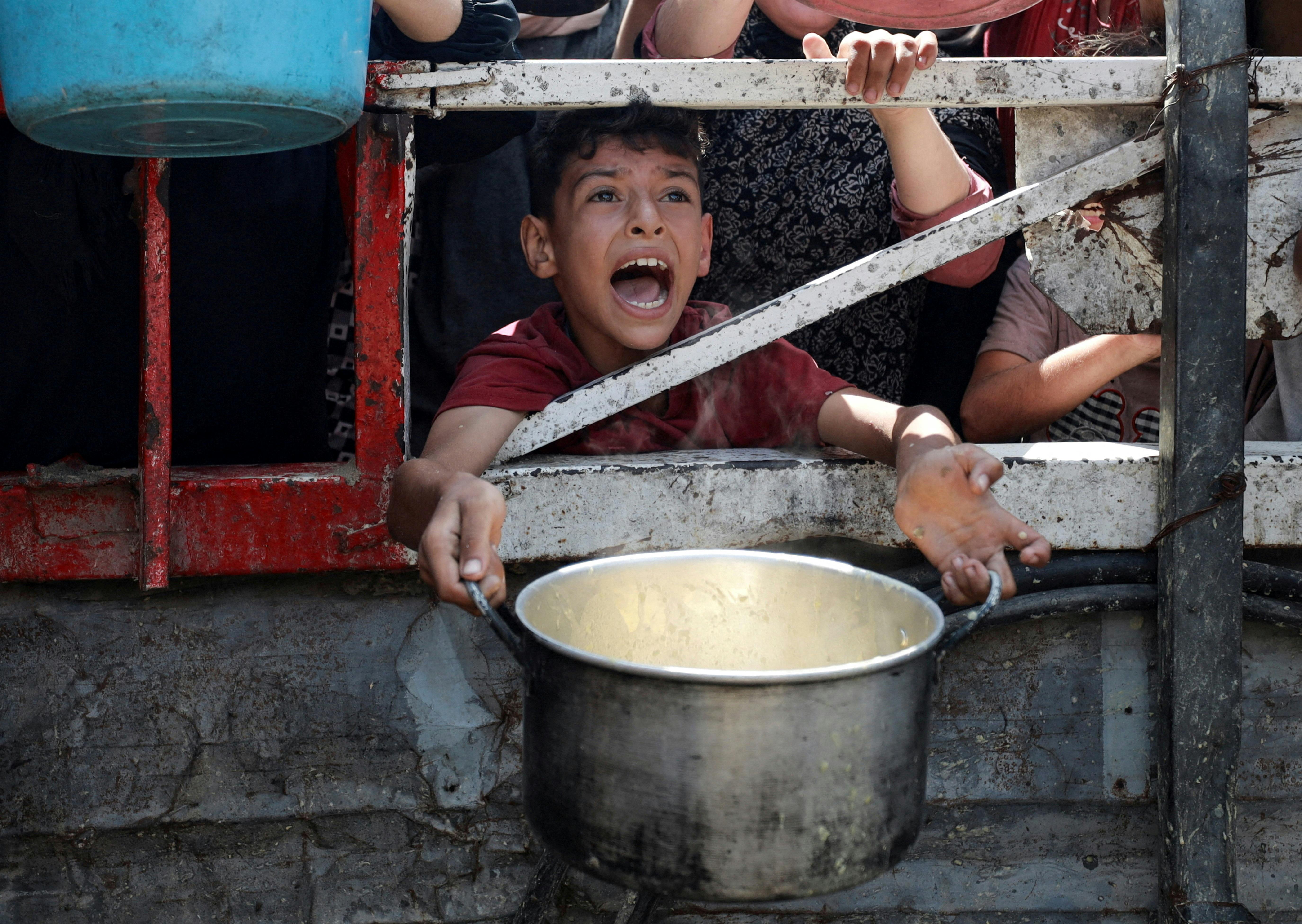 A Palestinian reacts as he waits to receive food from a charity kitchen, amid a hunger crisis, in Gaza City, July 28, 2025. REUTERS/Khamis Al-Rifi