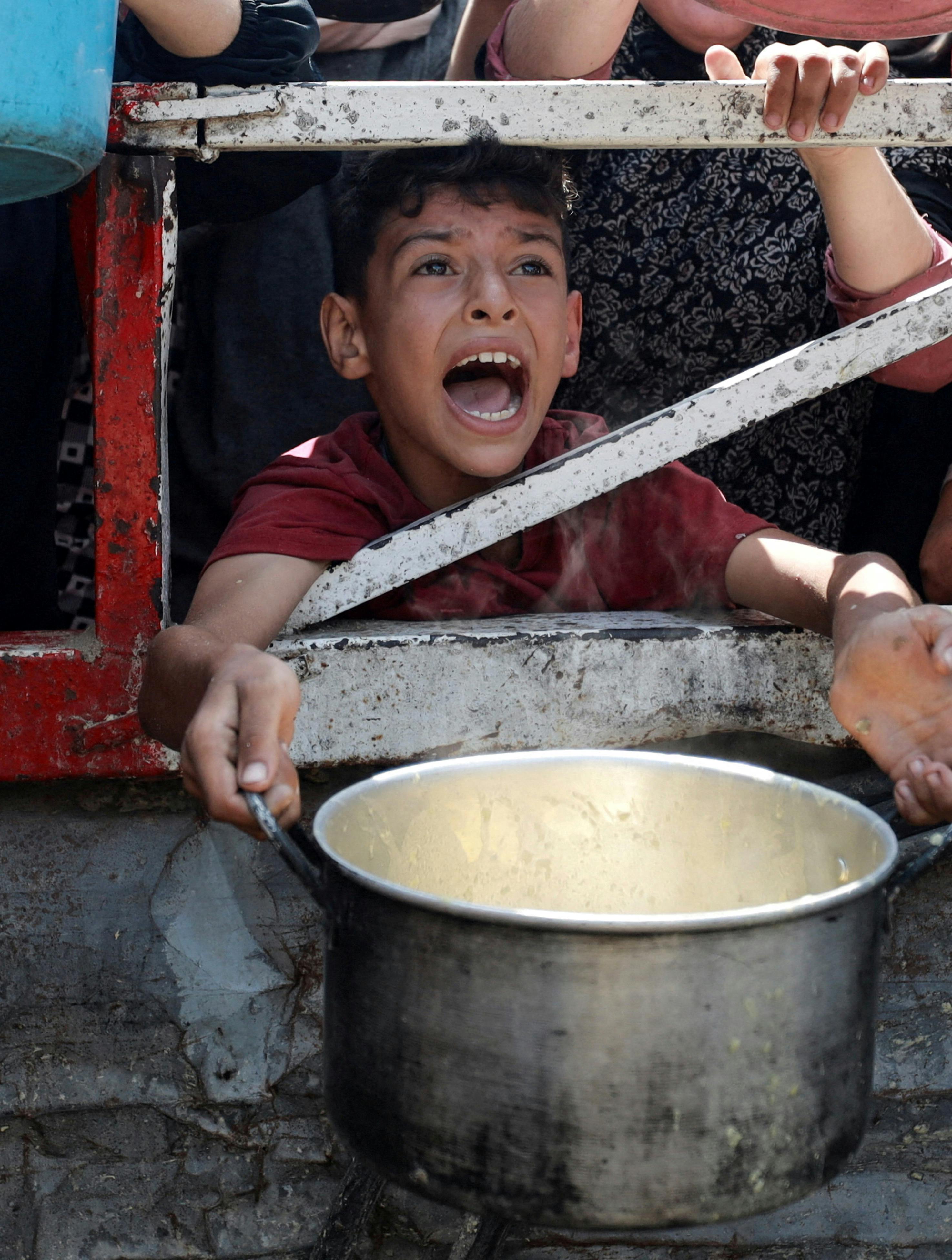 A Palestinian reacts as he waits to receive food from a charity kitchen, amid a hunger crisis, in Gaza City, July 28, 2025. REUTERS/Khamis Al-Rifi