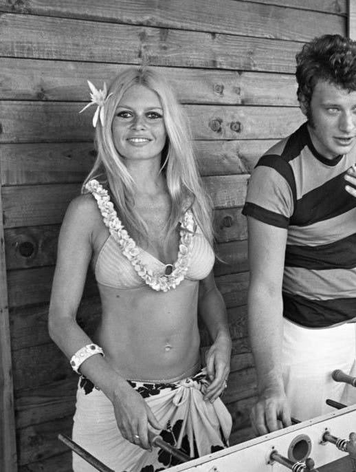 Brigitte Bardot en bikini et paréo et Johnny Hallyday jouant au baby-foot à l'hôtel Epi-plage à Saint-Tropez en août 1967 (Photo by Jean-Pierre Bonnotte/Gamma-Rapho via Getty Images)