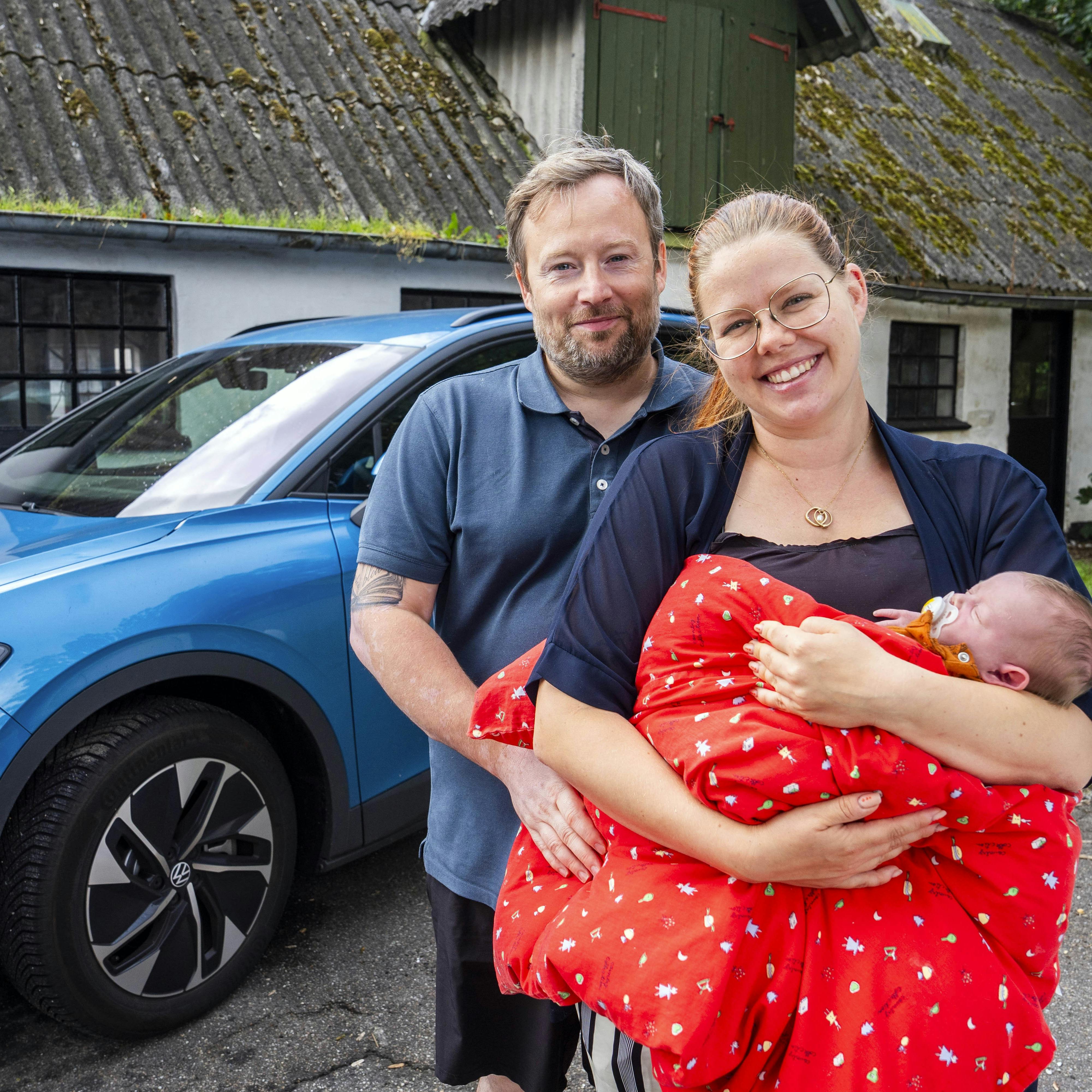Morten og Phie Herrguth Lambert ses her med datteren Neel foran deres Volkswagen ID4, hvor den lille pige kom til verden på passagersædet.