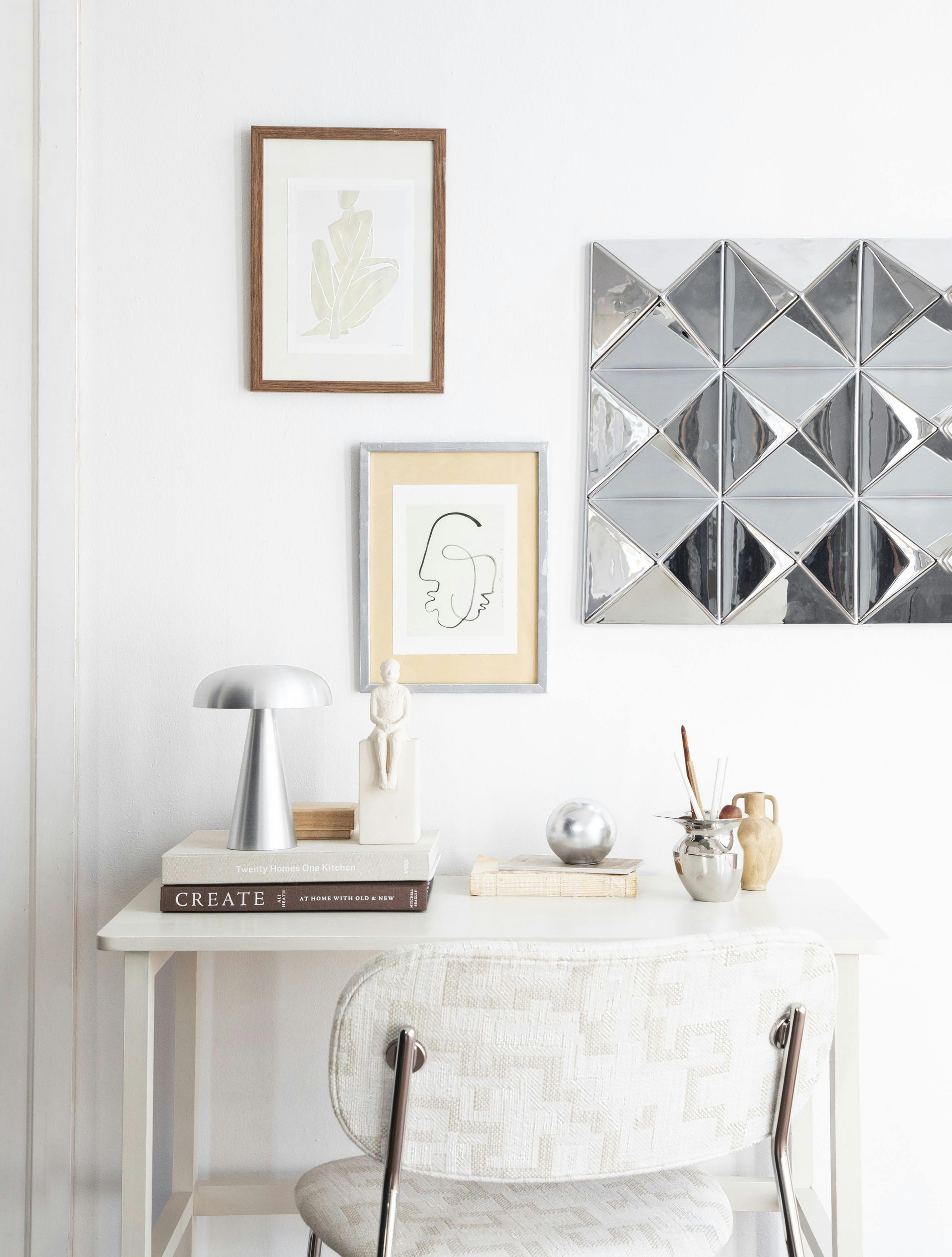 Lille ramme af træ og kunstkort fra Poster & Frame, stål-dekoration til væg og stol med kromben fra Verpan, bordlampe fra &Tradition, gipsfigur fra Kähler, mini-vase fra Ferm Living, sølvkande fra Audo Copenhagen, trææske fra Sakura Copenhagen og skrivebord fra Søstrene Grene.
