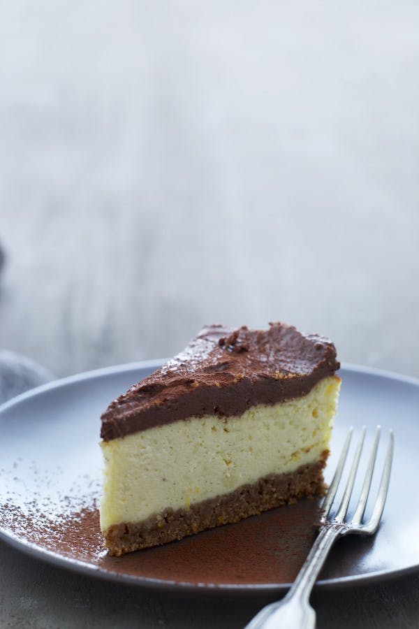 Lækker bagt cheesecake med chokoladetopping og kakaopulver