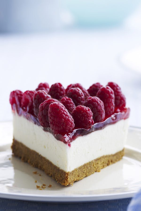Cheesecake med ripsgele, kiksebund og hindbær på toppen