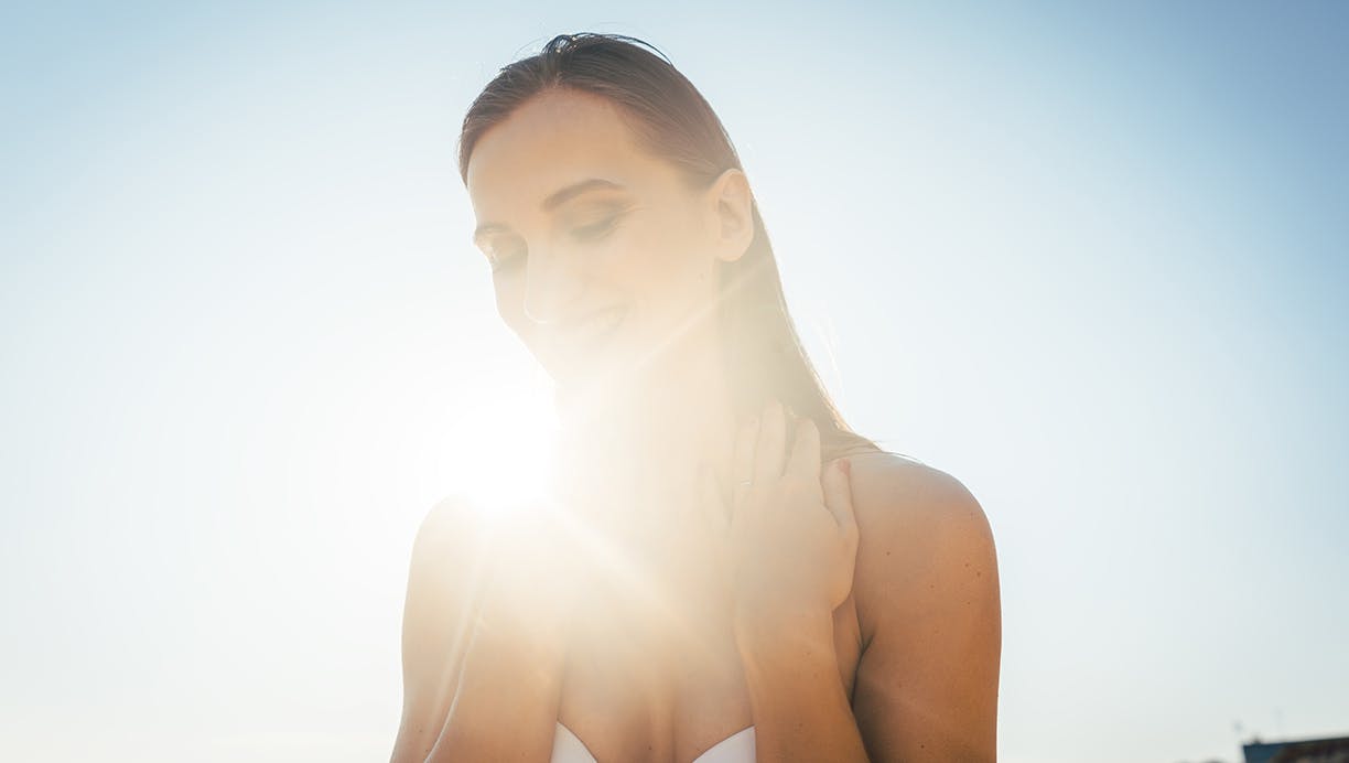 Dame på stranden i solen