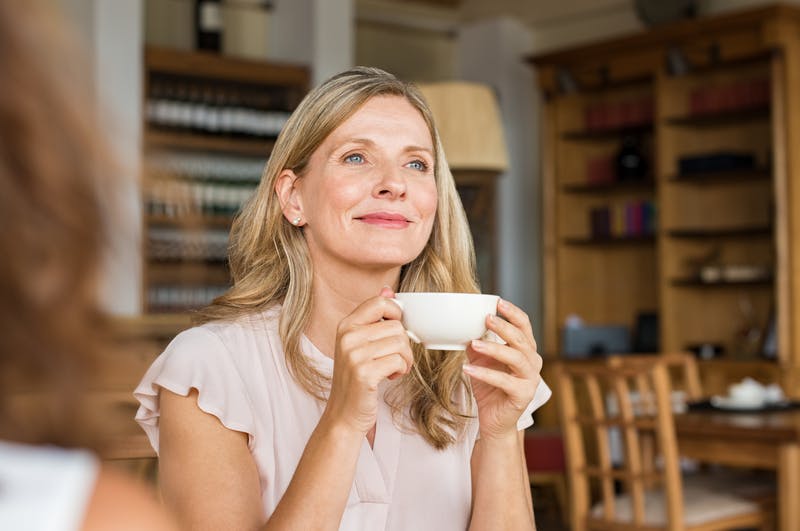 dame i godt humør med en kop kaffe